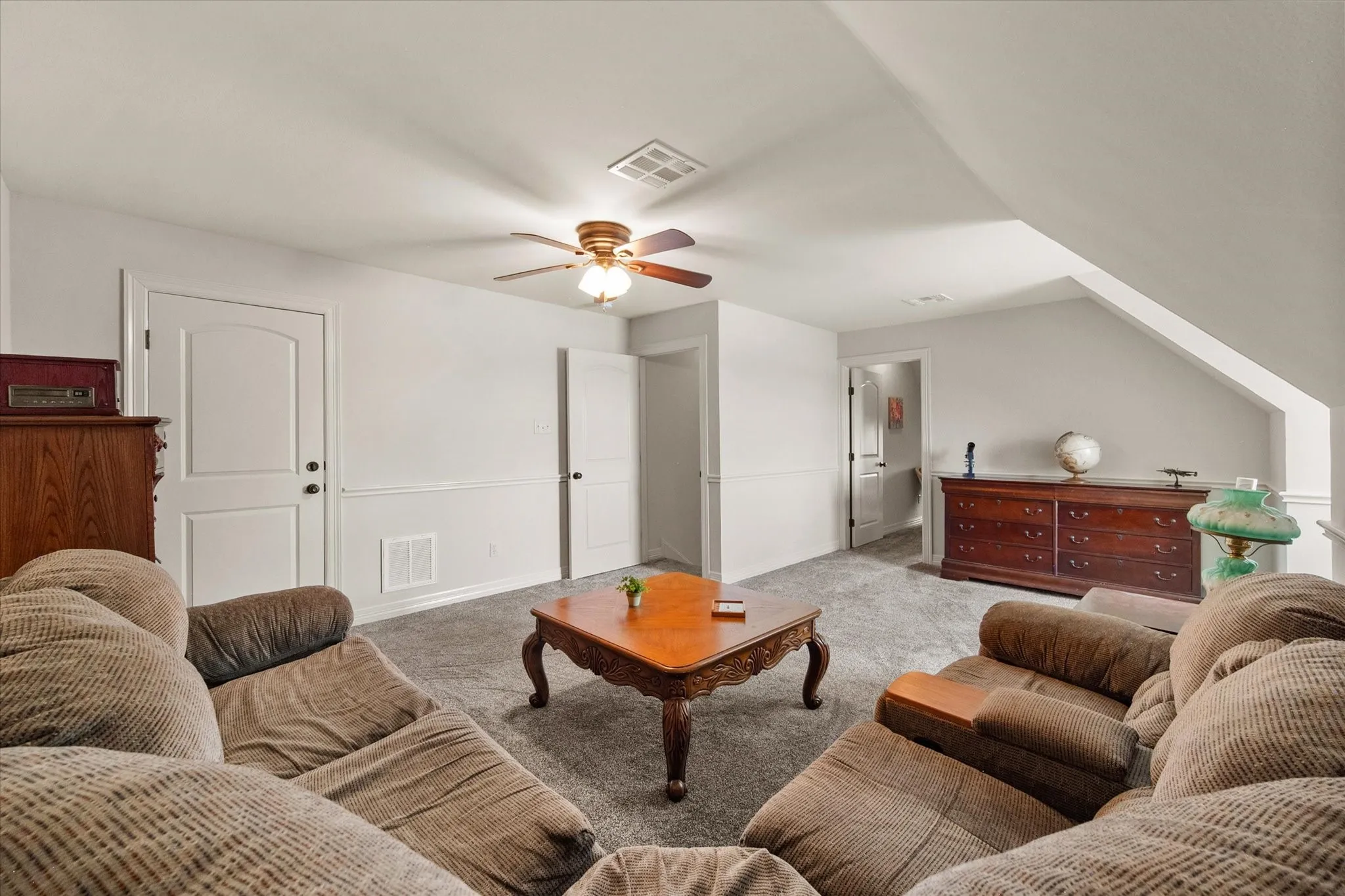 Flex room featuring a ceiling fan with integrated lighting, white walls, and wainscoting