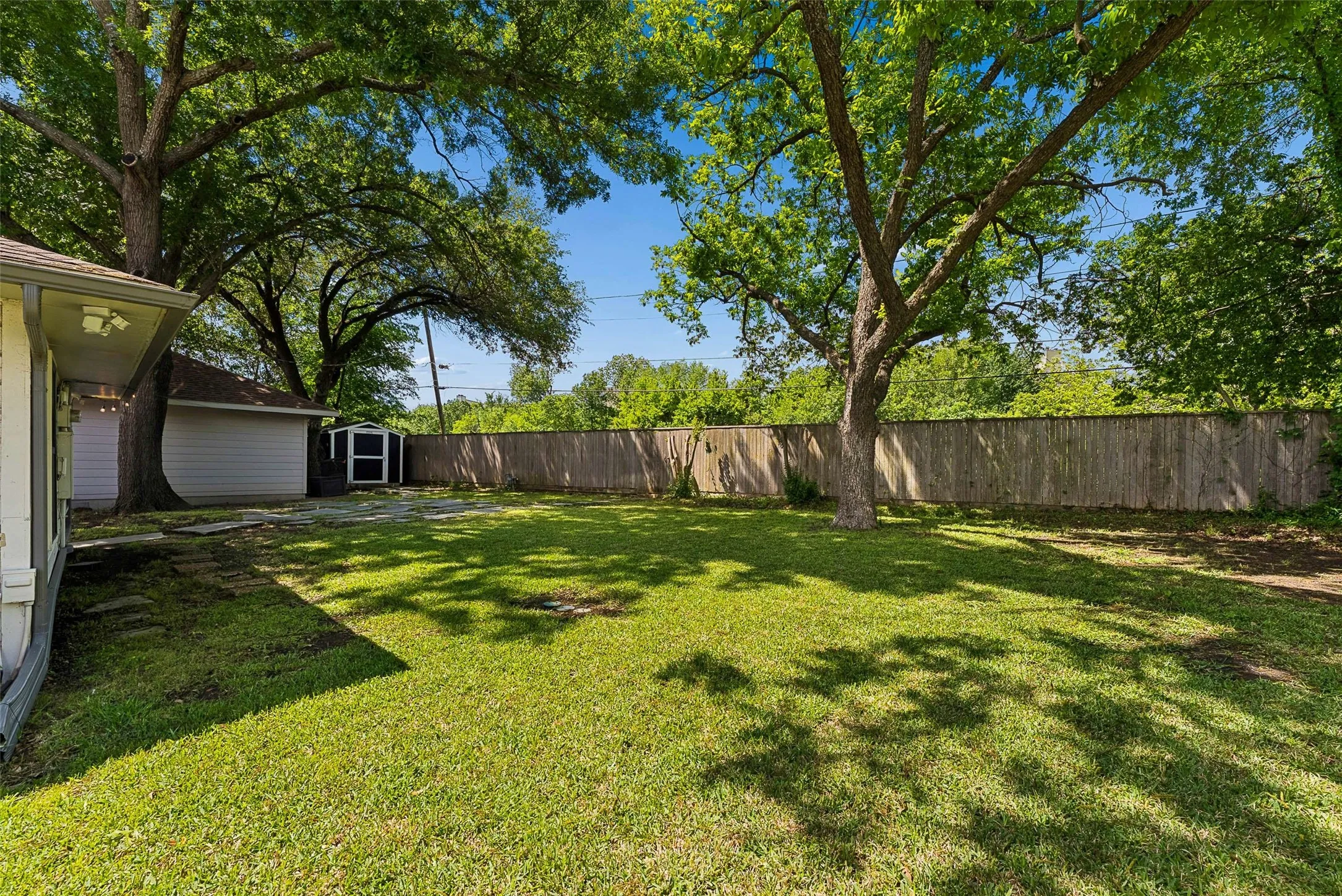 Large backyard with mature trees.