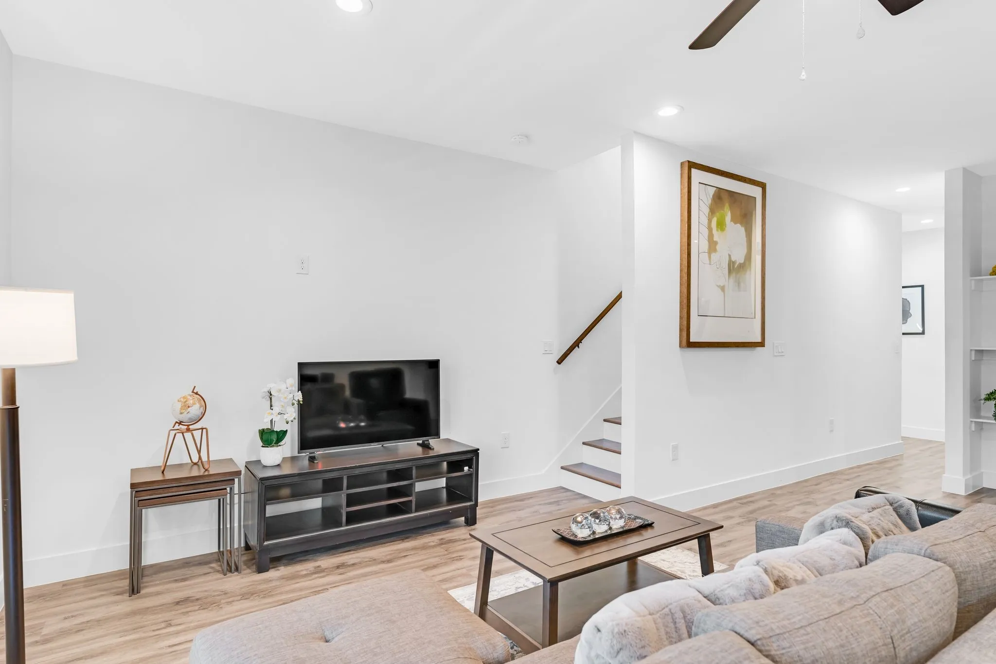 Living area featuring light wood-look flooring, recessed lighting, and a ceiling fan