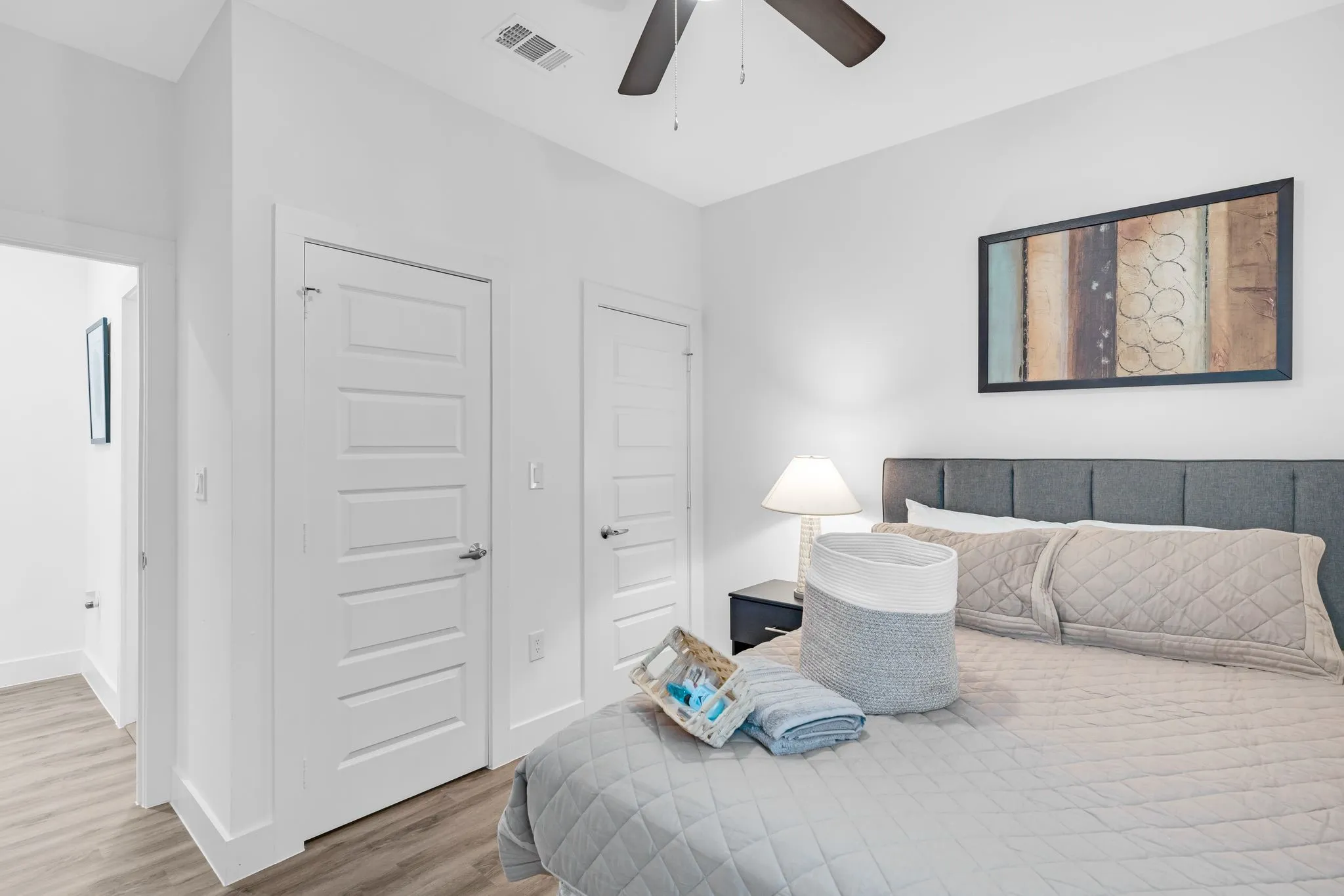 This room features light-colored walls, a ceiling fan, and modern paneled doors