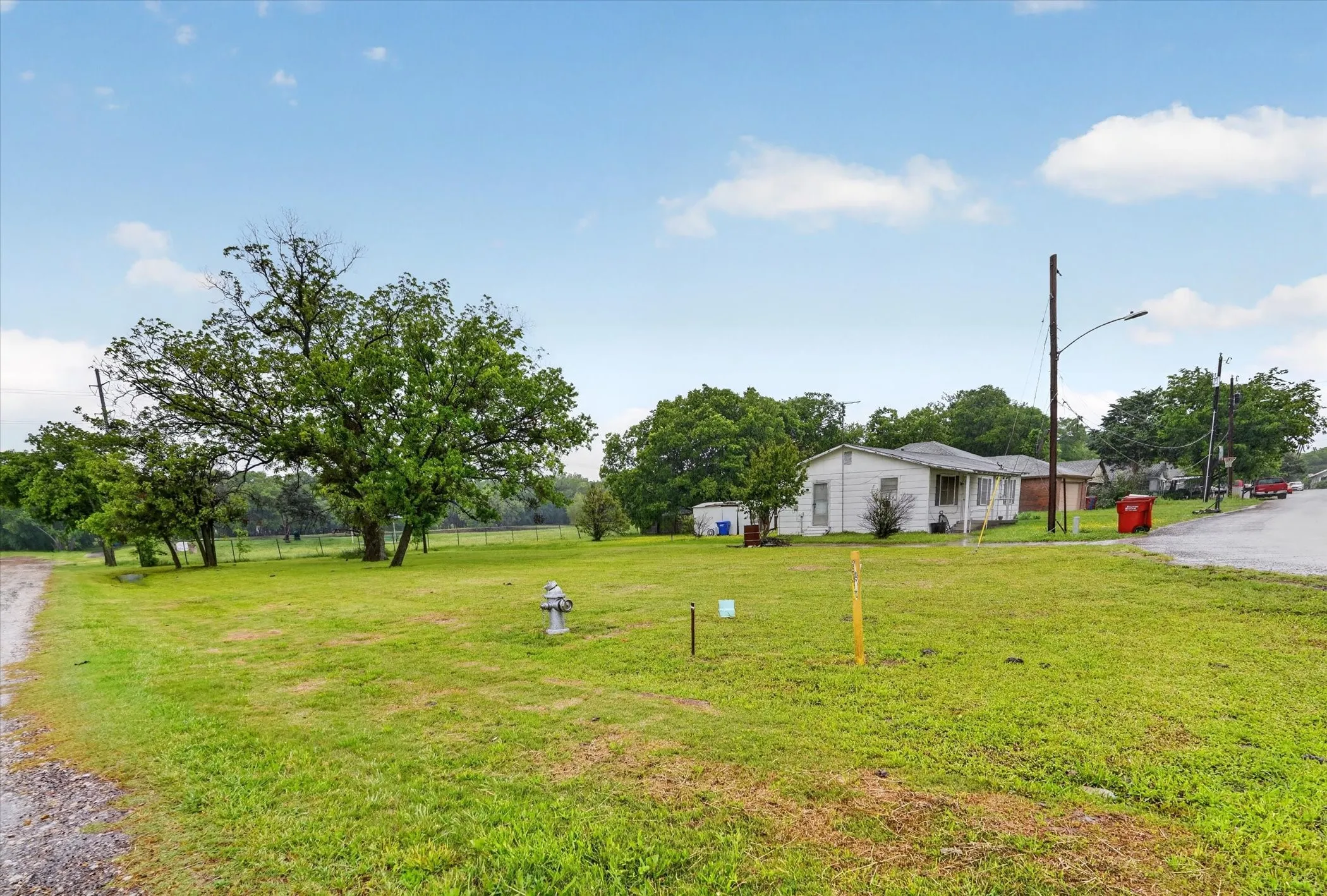Expansive green acreage featuring a private dirt path, mature trees, and a pond