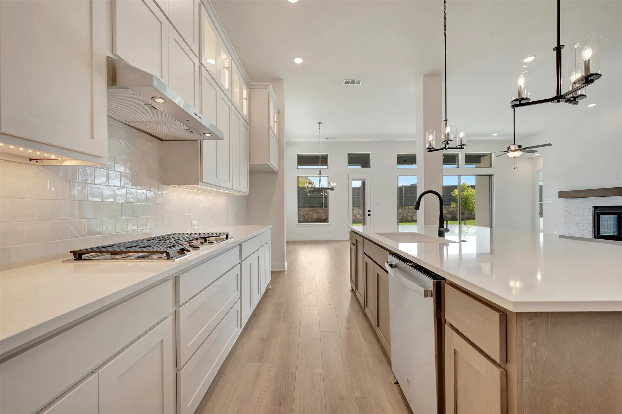 Modern kitchen with light wood-finish flooring and white cabinetry