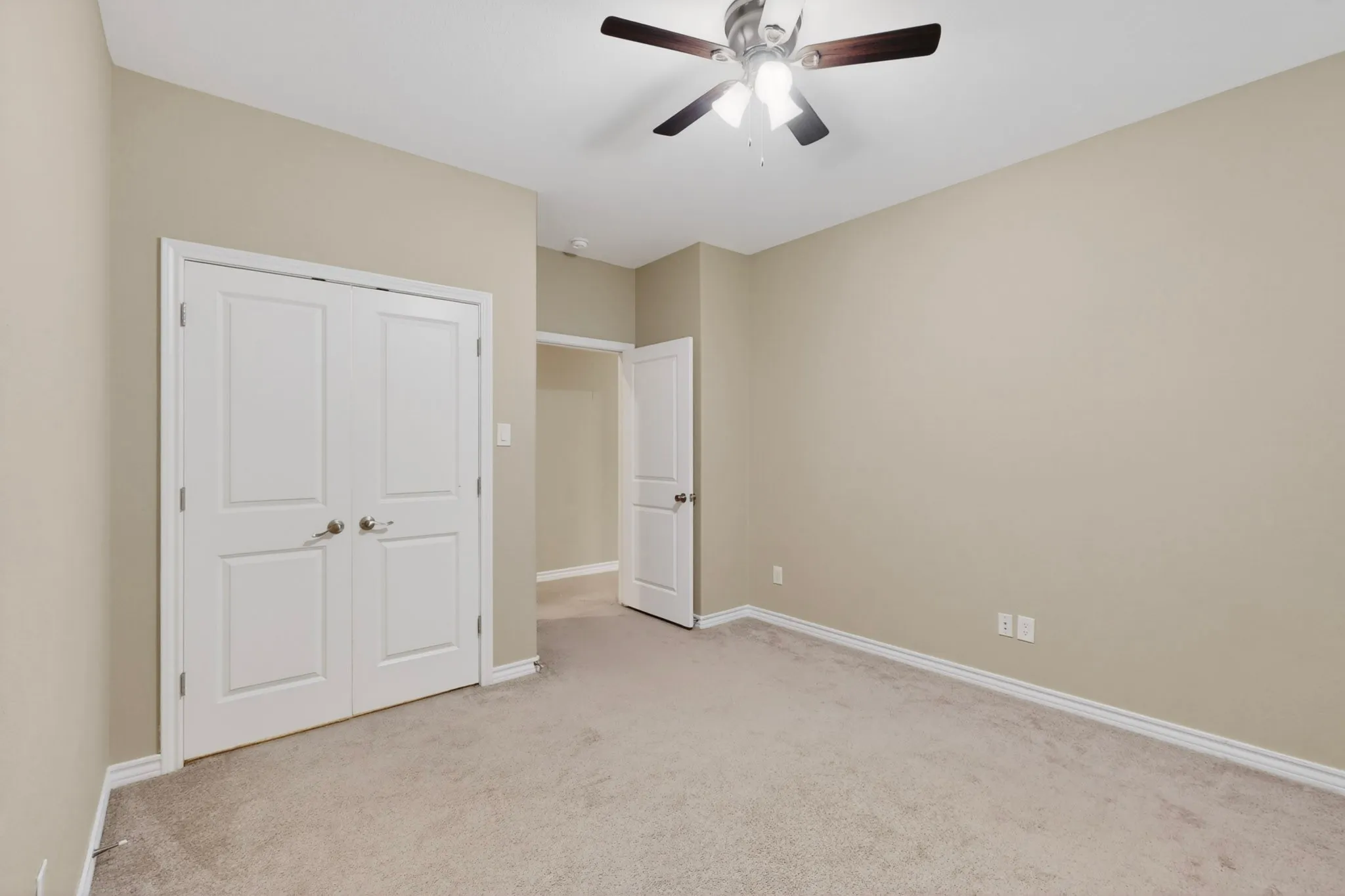 Neutral-toned room with light beige walls and light-colored carpeting