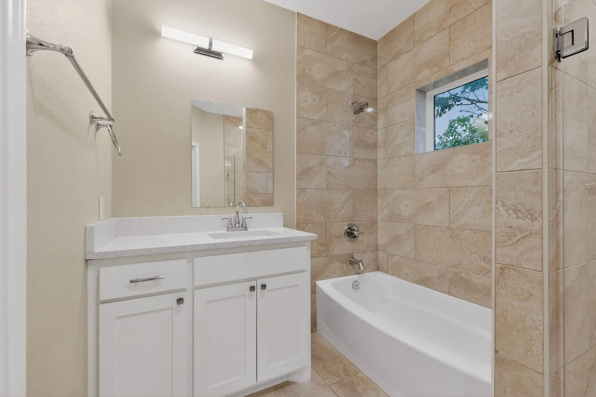 Bathroom featuring a white vanity with a light-colored countertop, an integrated sink, and chrome fixtures