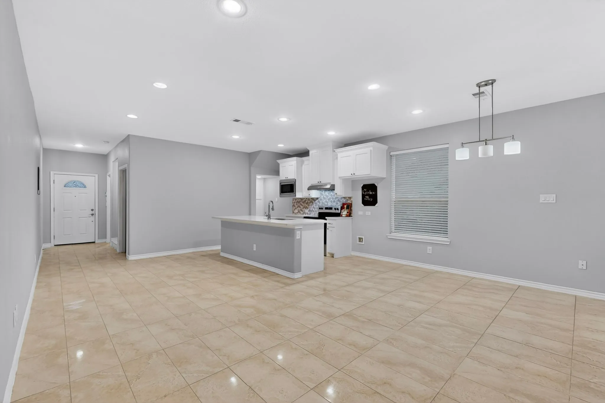 Open-concept living space featuring neutral paint, recessed lighting, and tile flooring