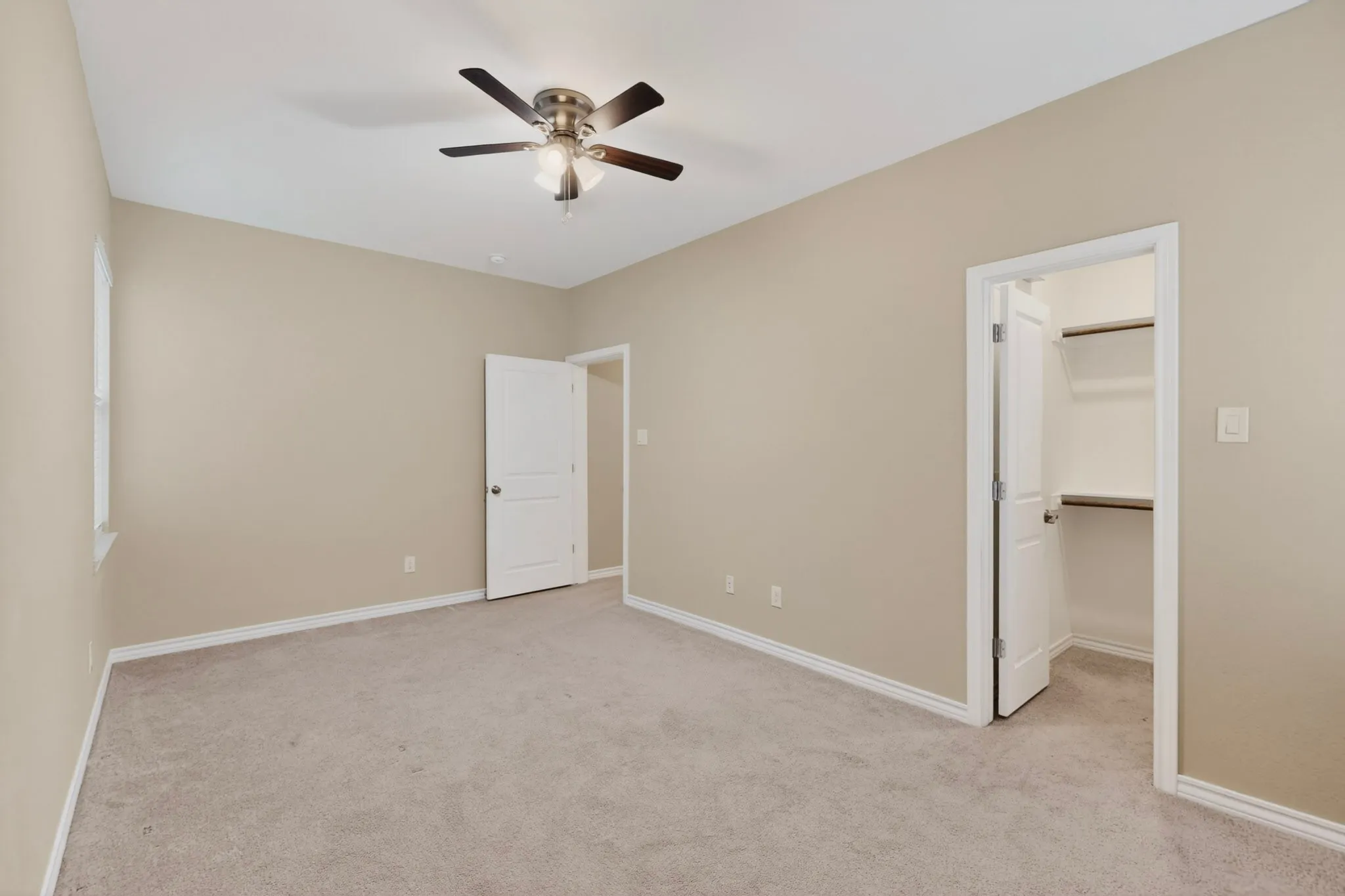 Spacious room featuring neutral carpeting and light-toned walls