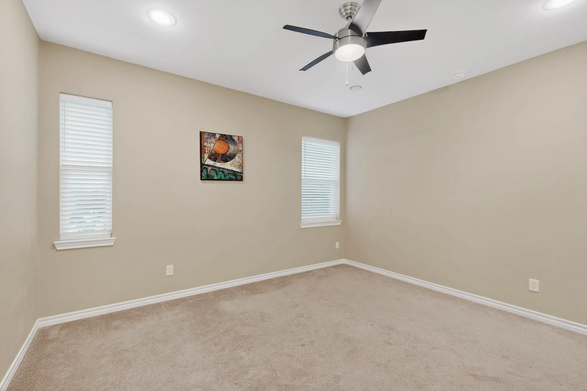 Carpeted room with neutral wall tones and white baseboards