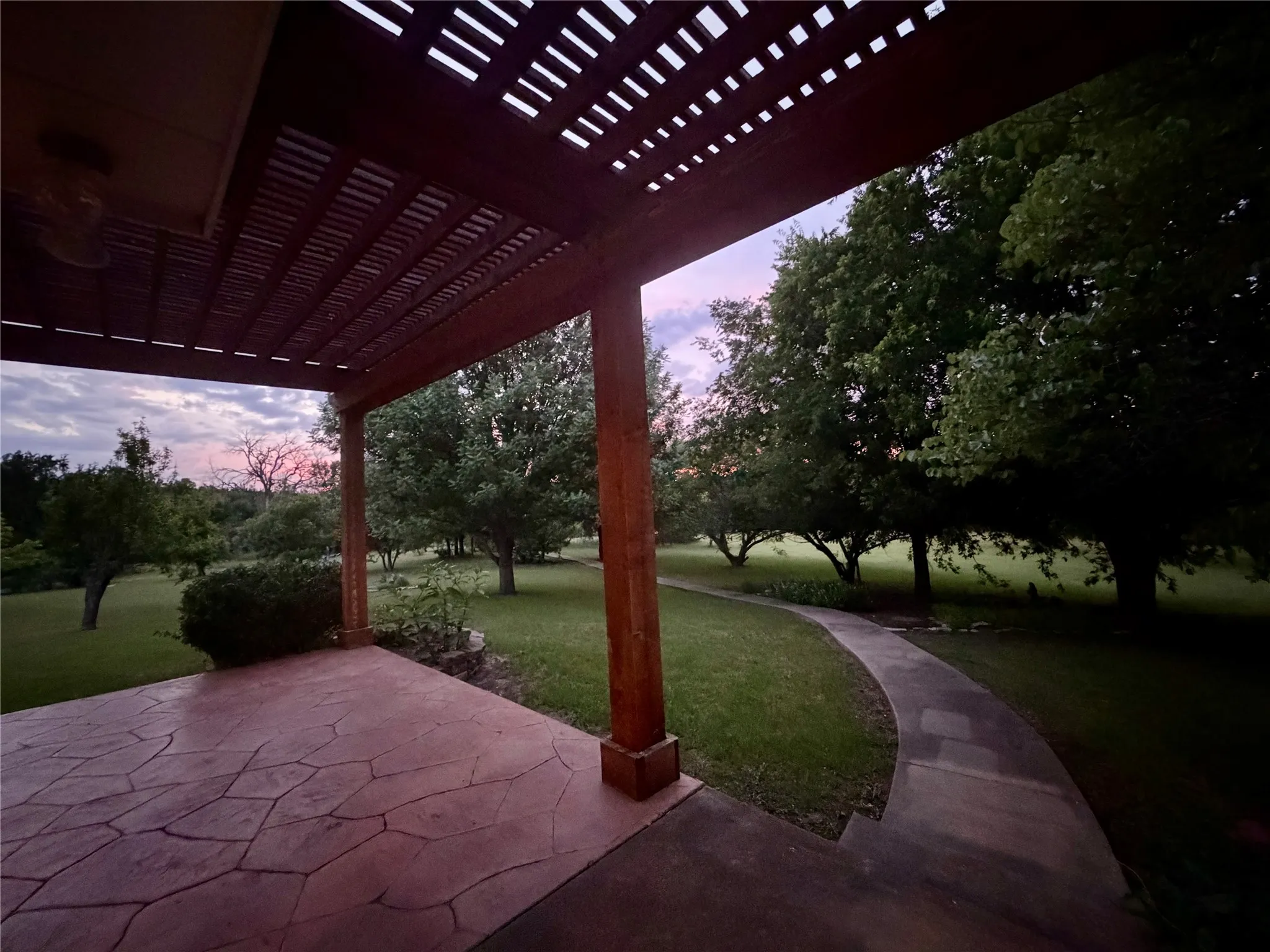 Expansive covered patio with a stamped concrete surface and wood pergola