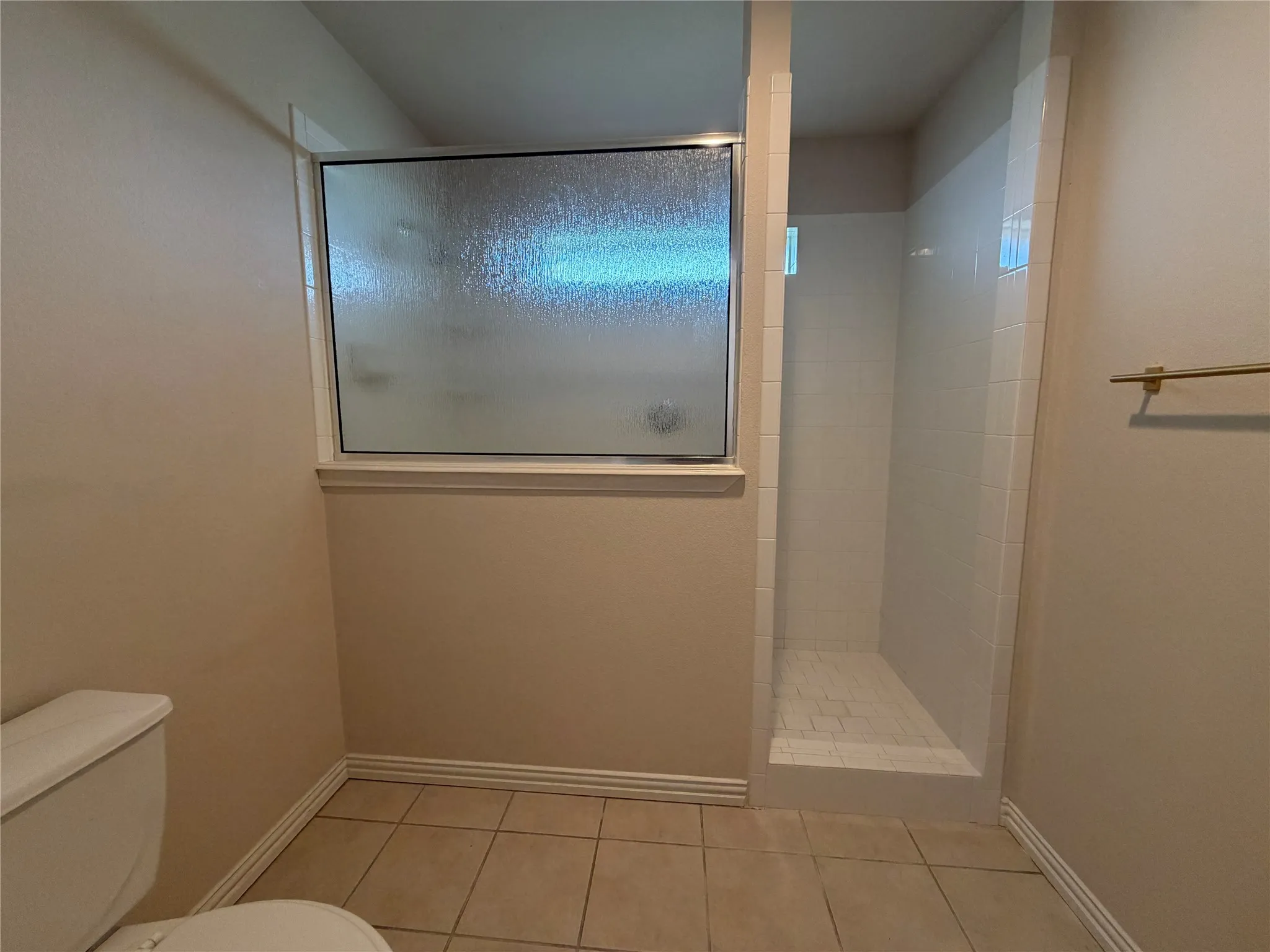 2nd bathroom Walk-in shower with white tile surround and a tiled base