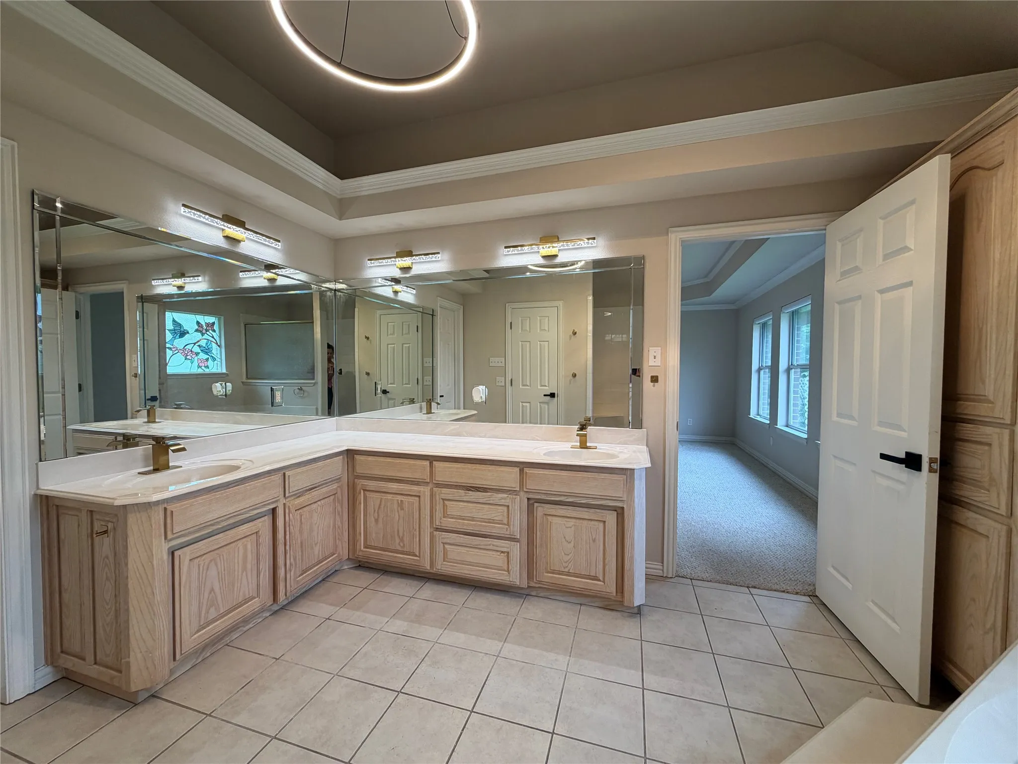 Spacious bathroom featuring a dual vanity with light-toned cabinetry and countertops