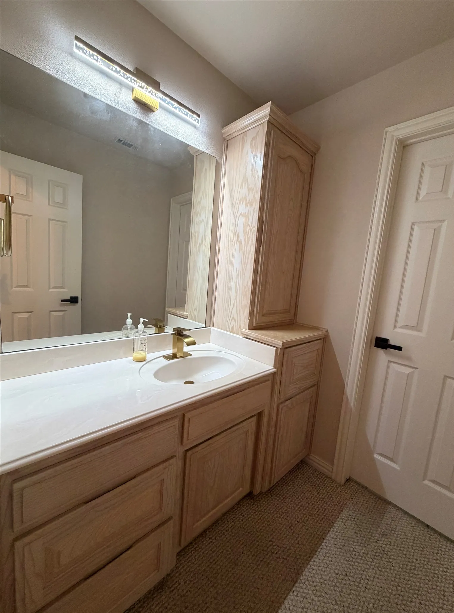 2nd Bathroom vanity with a light wood-finish cabinetry, a white countertop, and a single sink featuring brushed gold-tone fixtures