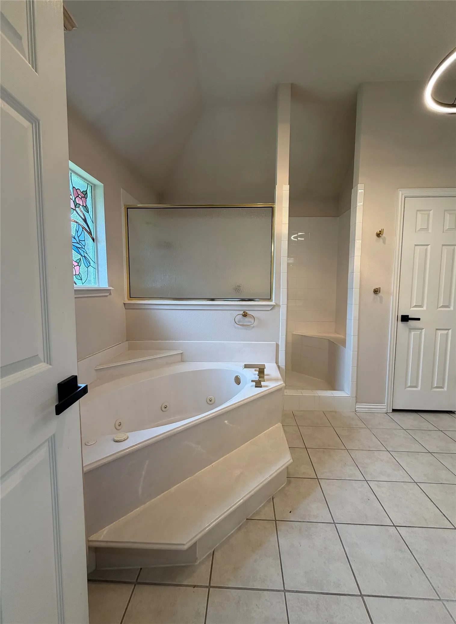 Jetted tub with integrated steps and brass-finish fixtures
