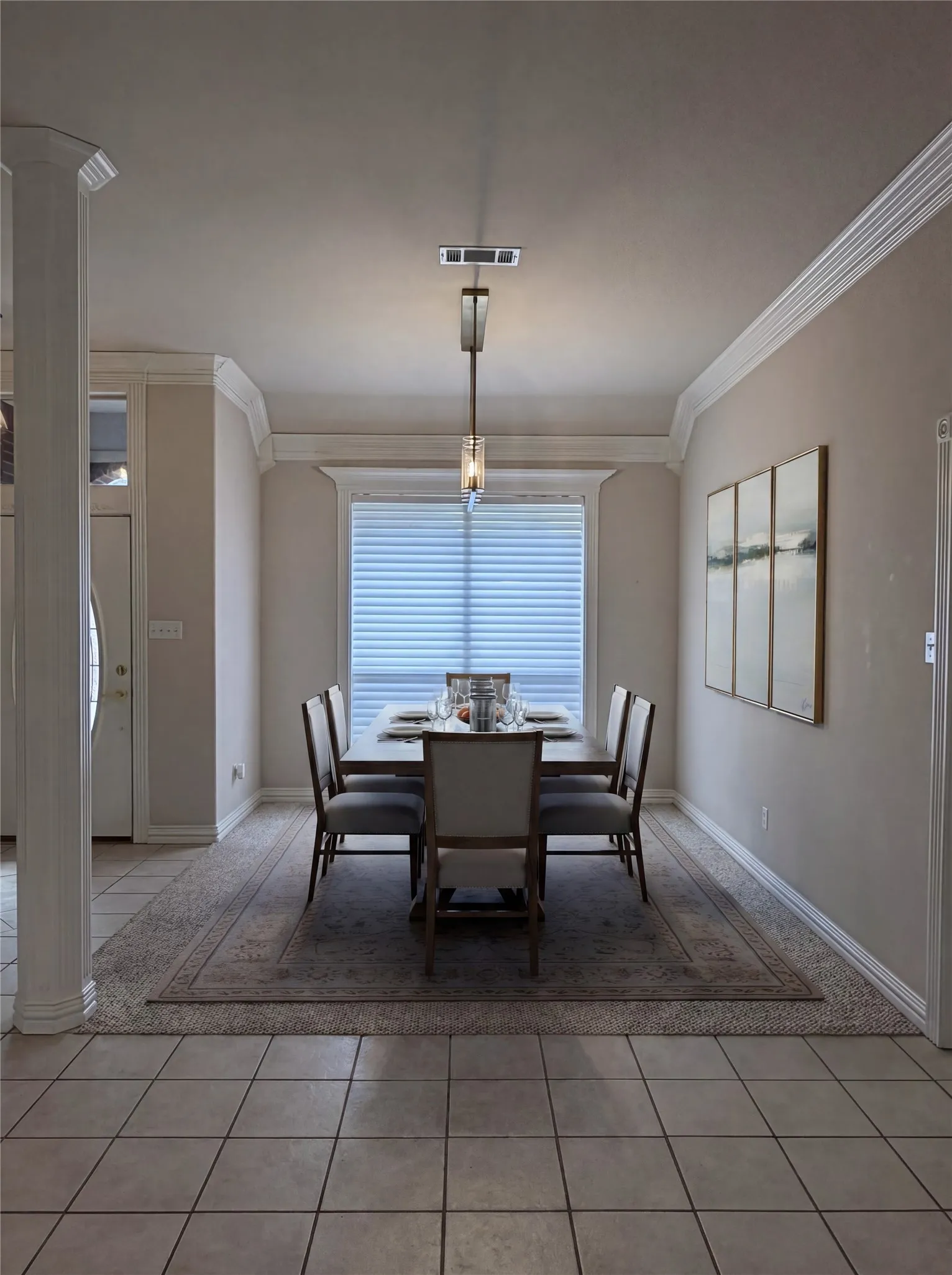 Formal dining space featuring crown molding and a prominent window with electric remote controlled blinds!