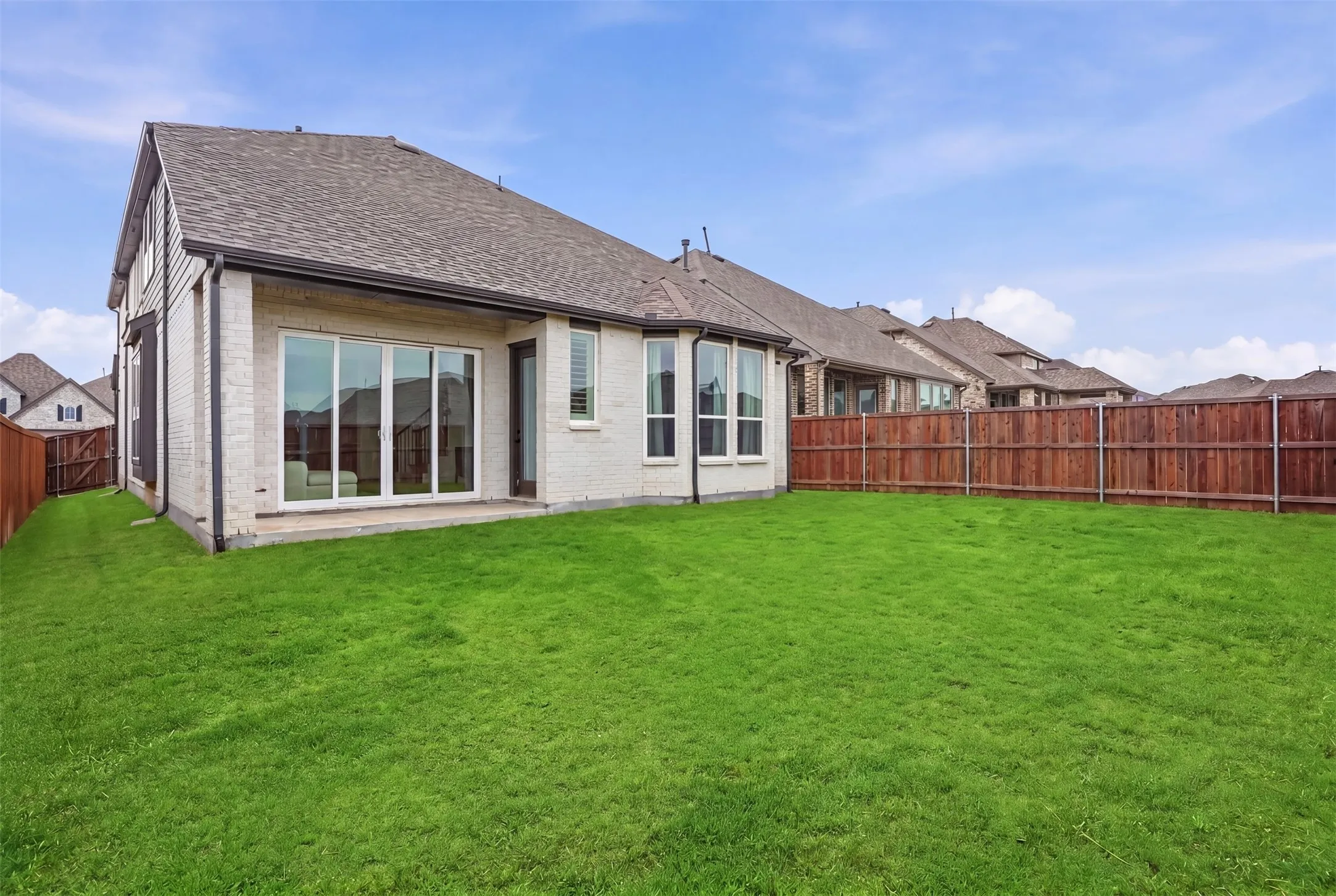 Expansive green lawn with a privacy fence