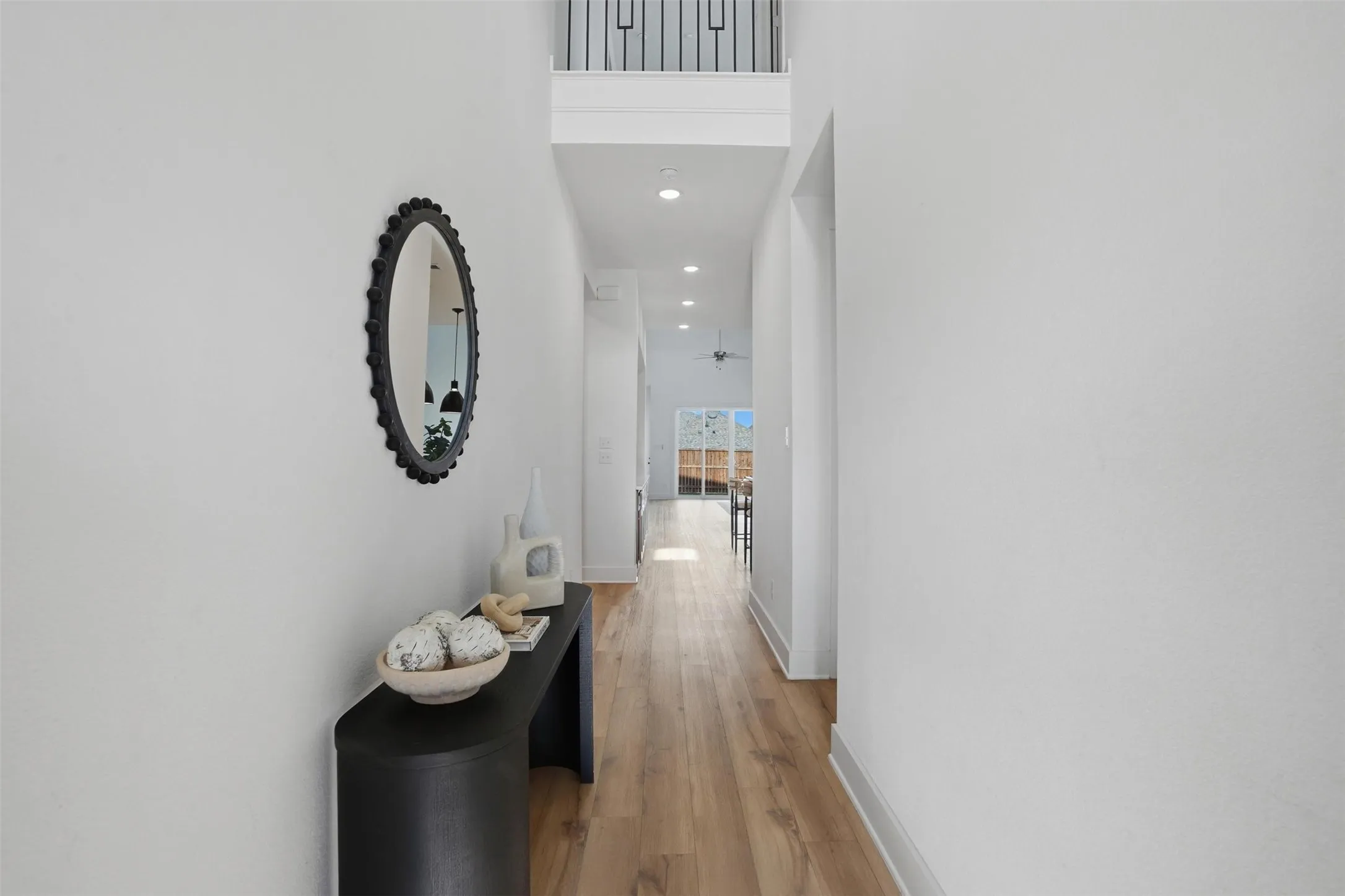 Bright hallway featuring light wood-finish flooring and recessed lighting