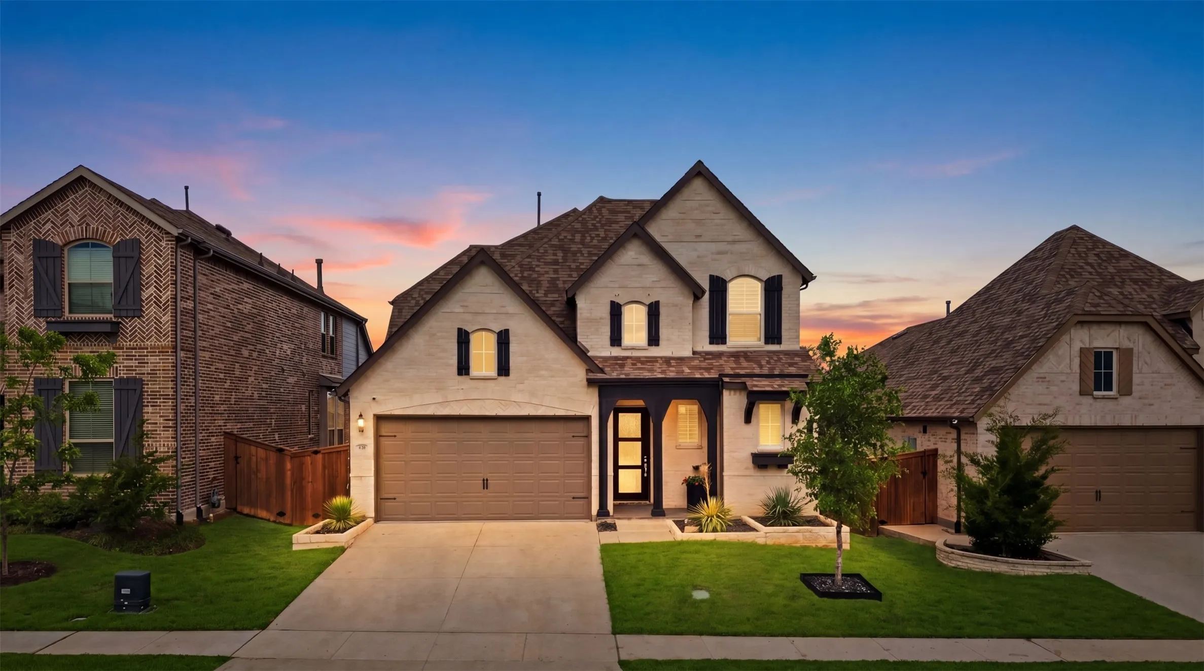 Two-story residence featuring a light brick facade with dark shutters and trim accents