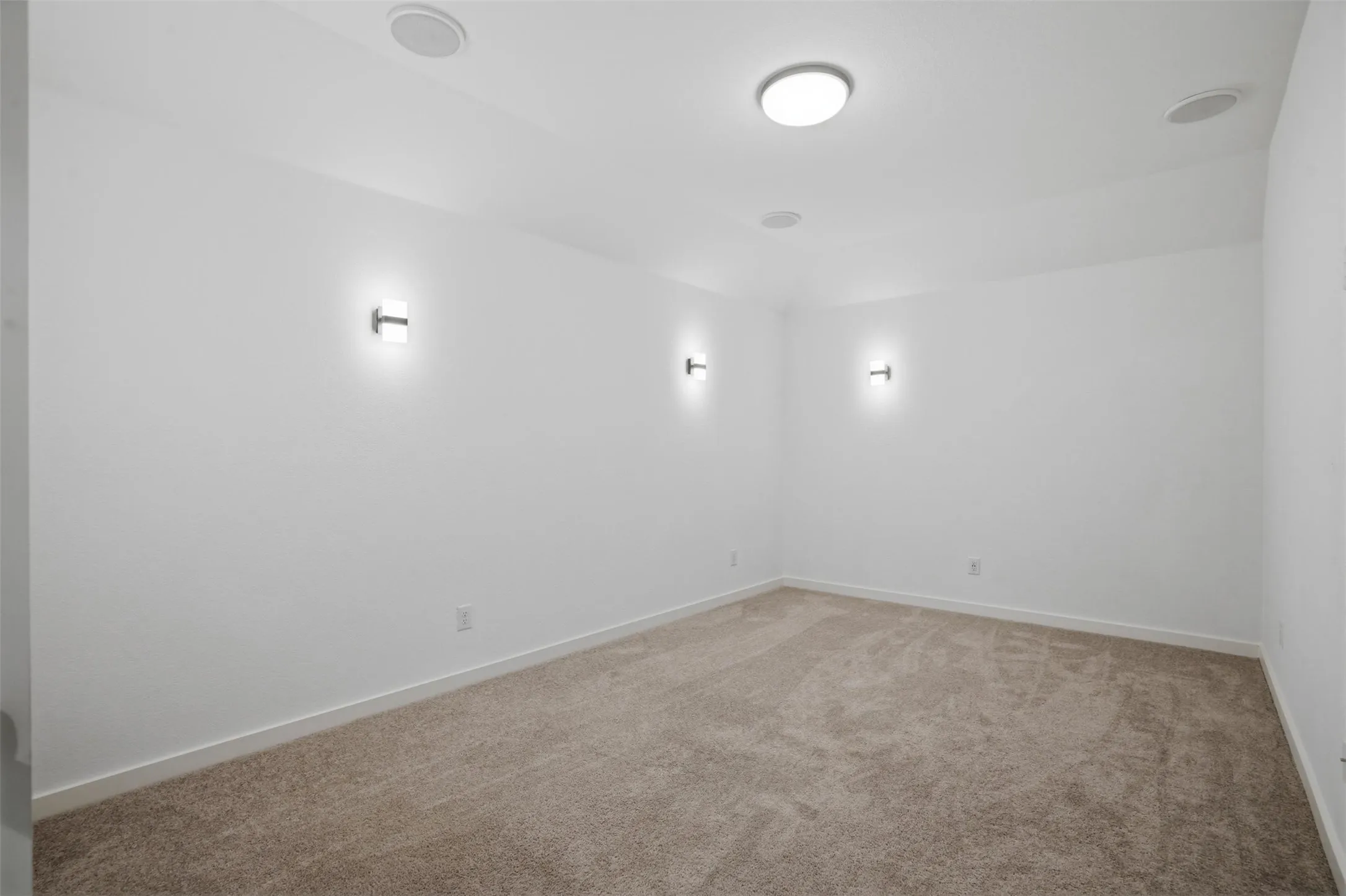 Carpeted room with recessed lighting, flush-mount ceiling light, and wall sconces