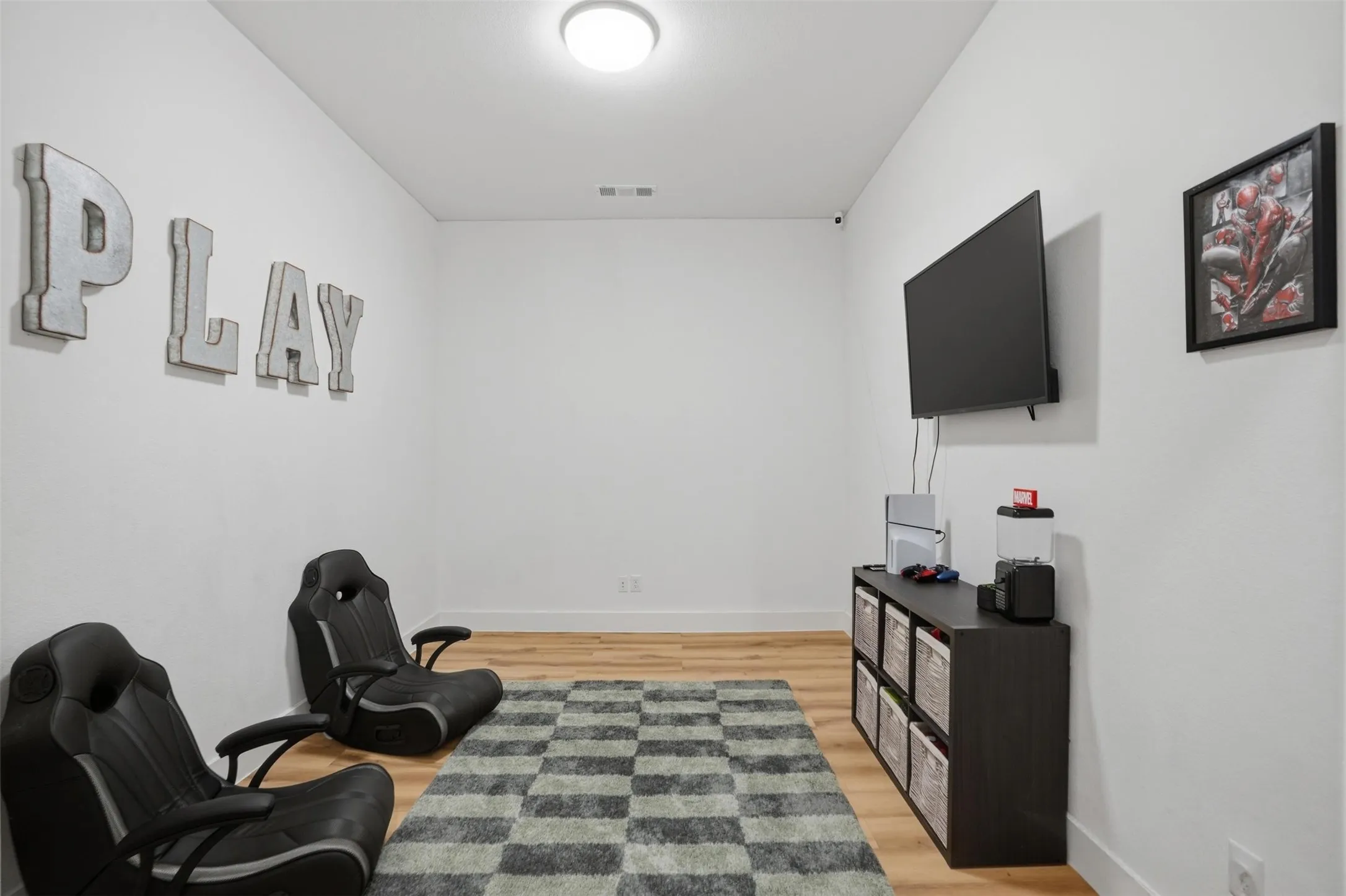 Bright interior space featuring light wood-finish flooring, white walls, and a flush-mount ceiling light fixture