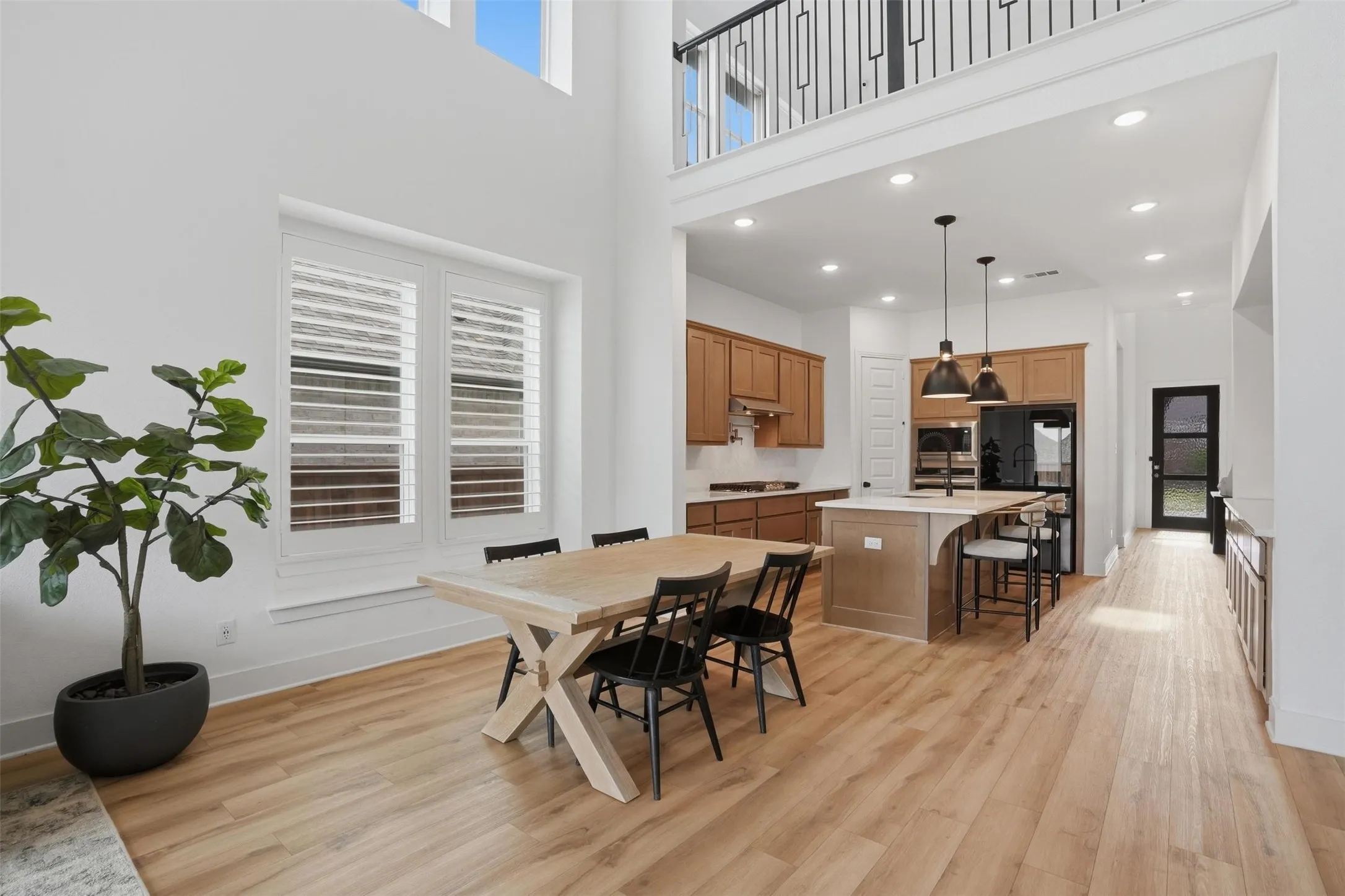 Open-concept living space featuring wood-finish flooring and high ceilings