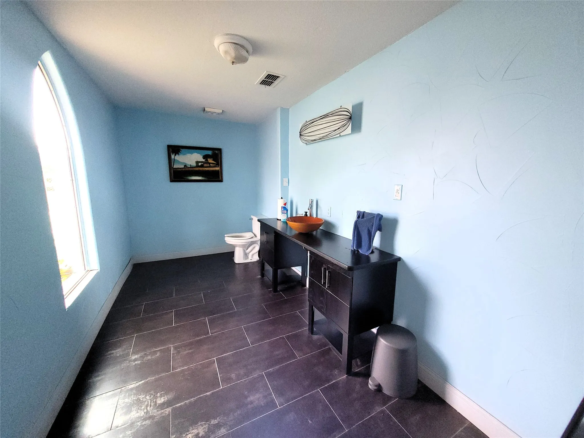 Large bathroom with vessel sink and tile flooring.