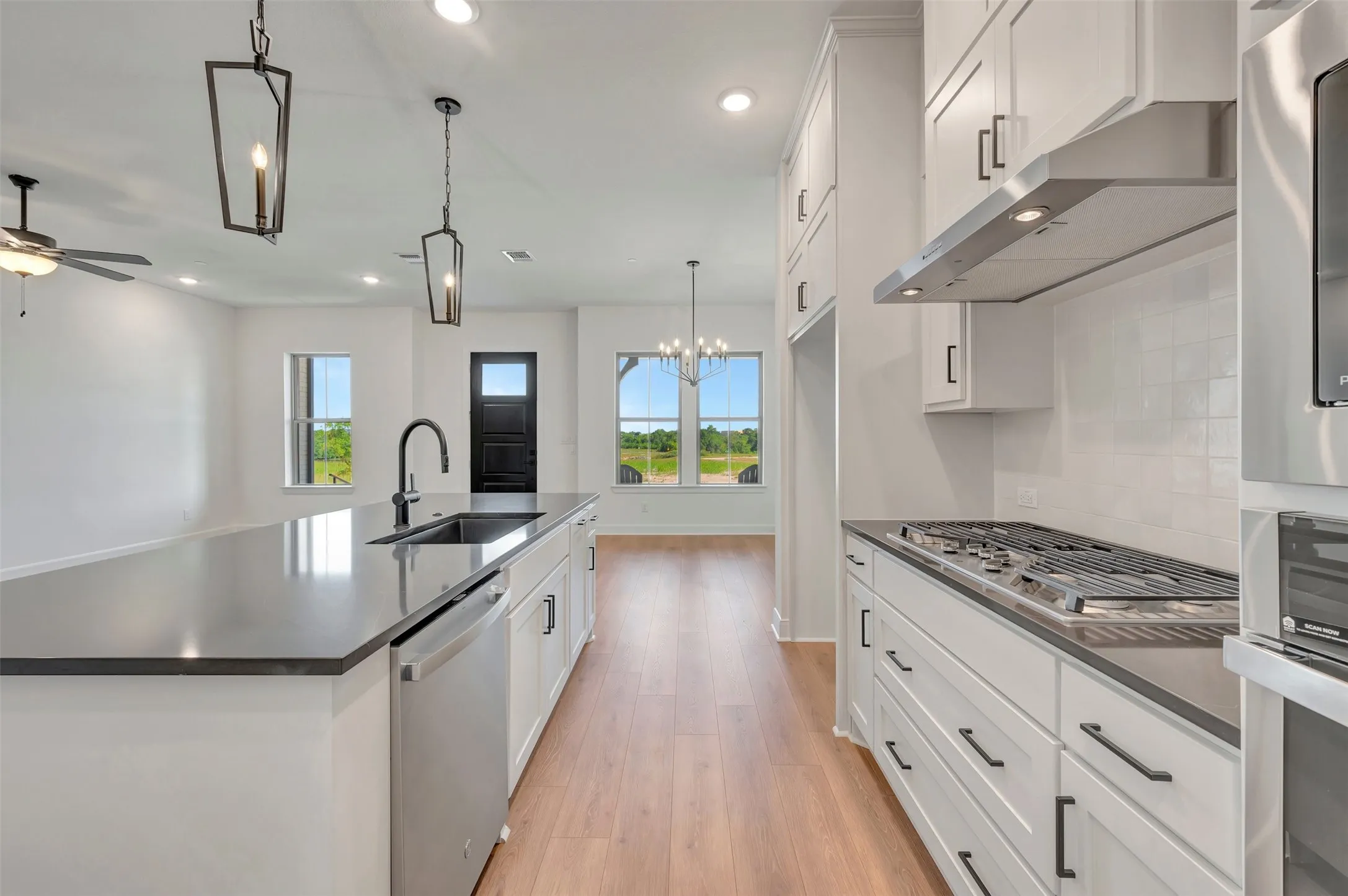 Modern kitchen featuring an expansive island with a built-in sink and stainless steel dishwasher