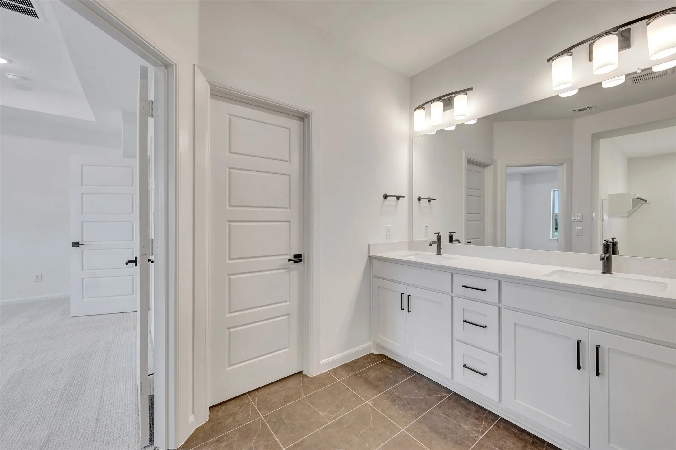 Dual vanity with white cabinetry and integrated sinks