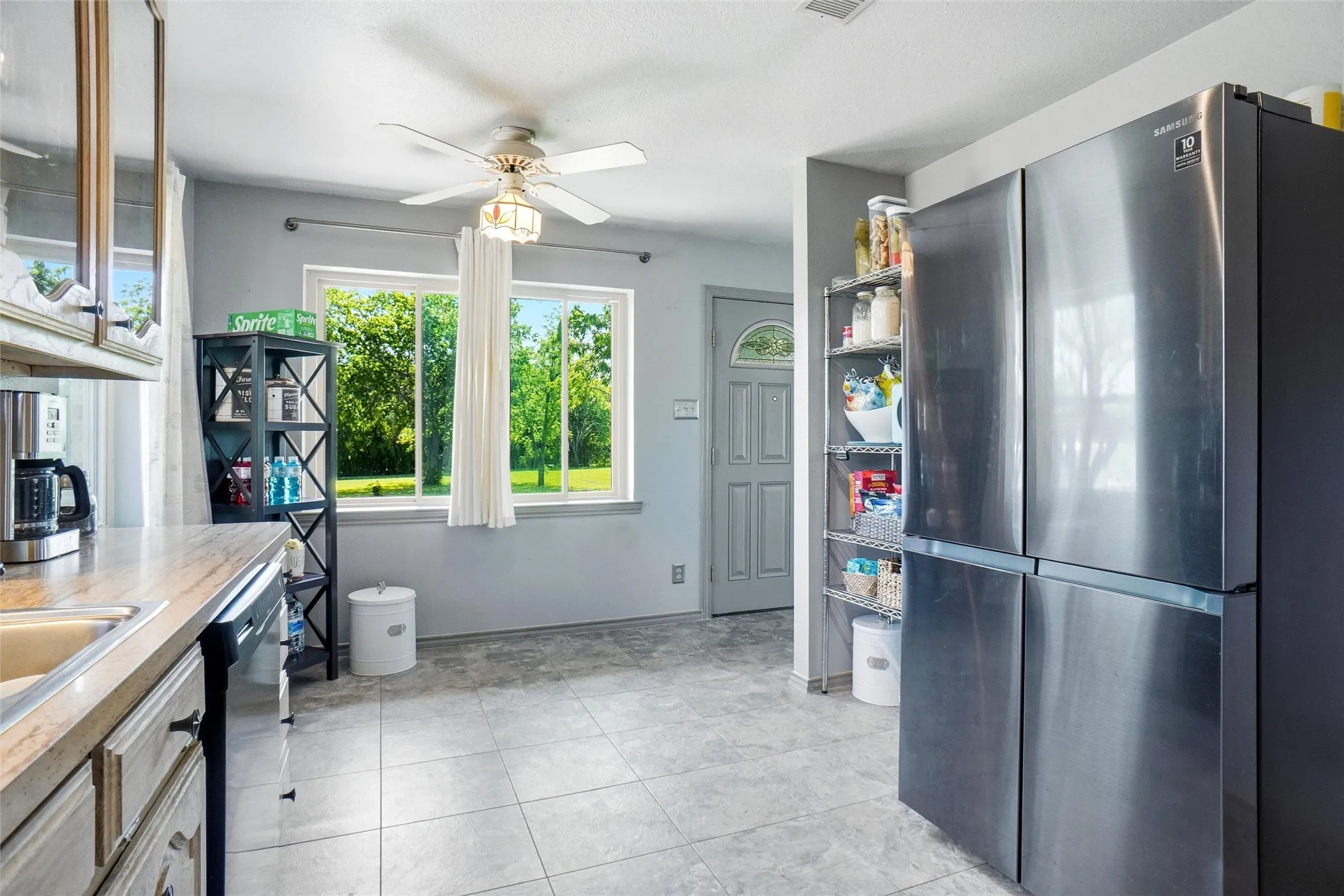 There are several great picture windows throughout the home for lots of natural lighting. View from kitchen looking at front entry doorway.
