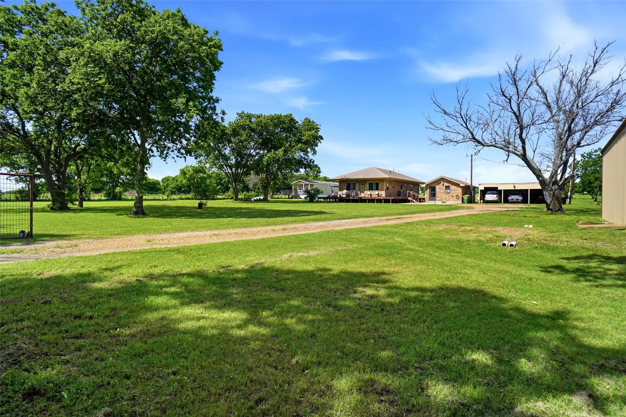 Property has electric gate.  There is a 3 carport structure and shop is on right hand side of the picture.