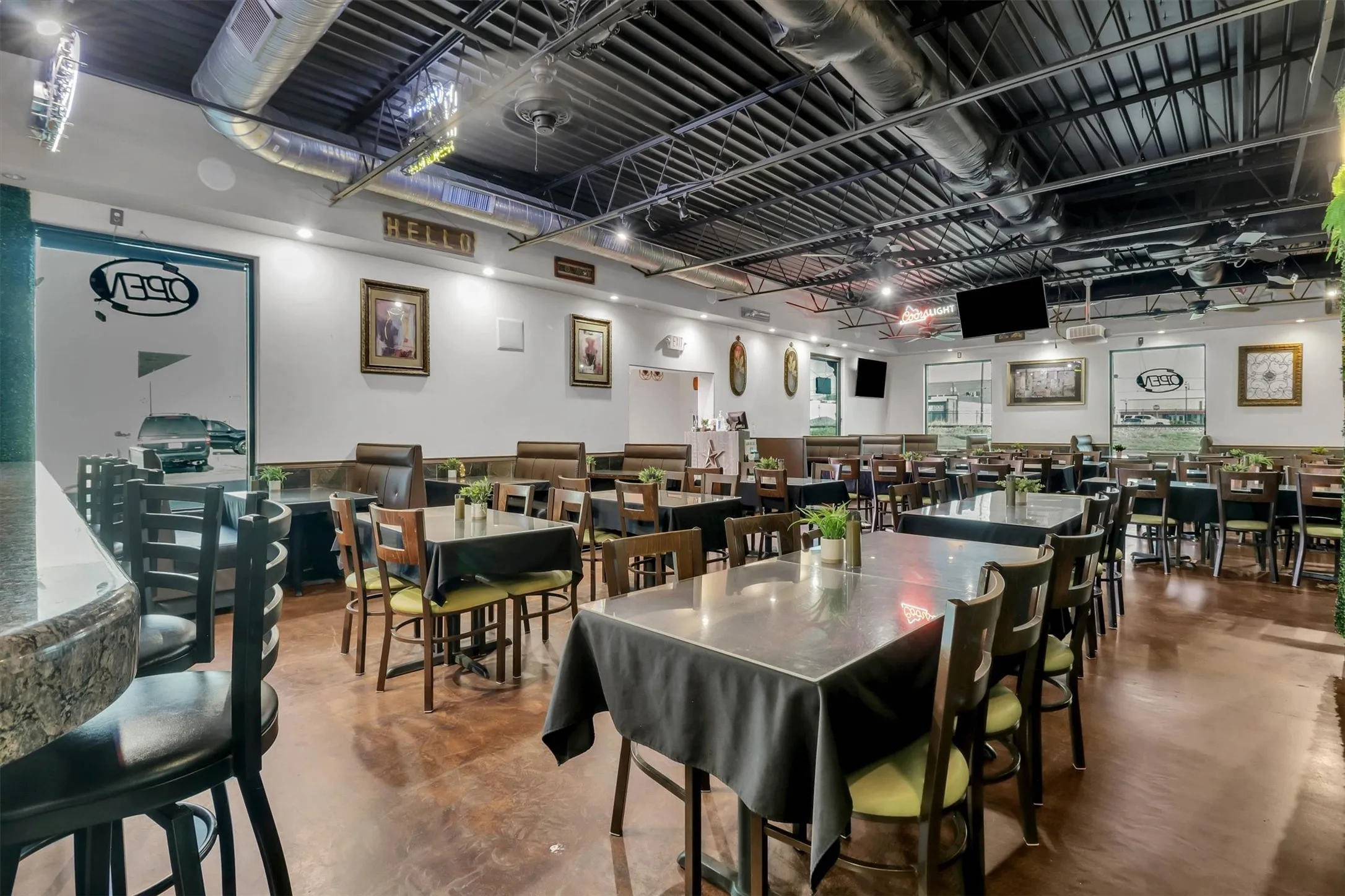 Spacious dining area featuring exposed ceiling ductwork, recessed lighting, and a polished concrete floor