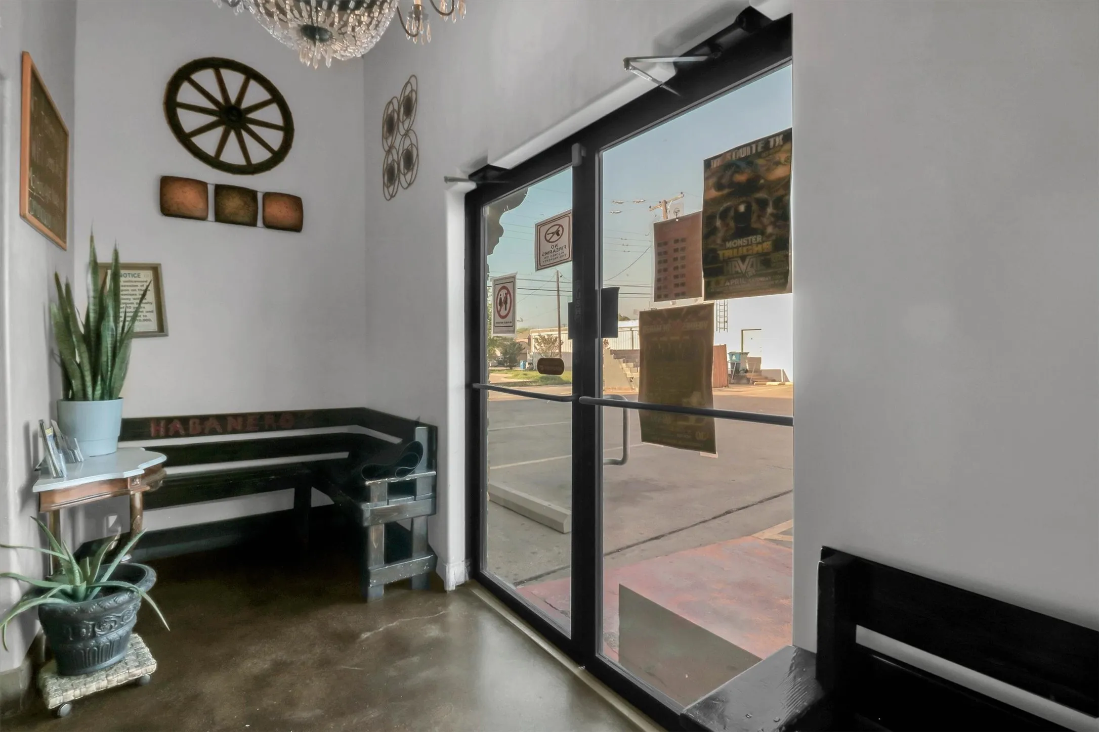 Commercial entrance featuring full-light glass doors and an overhead crystal chandelier