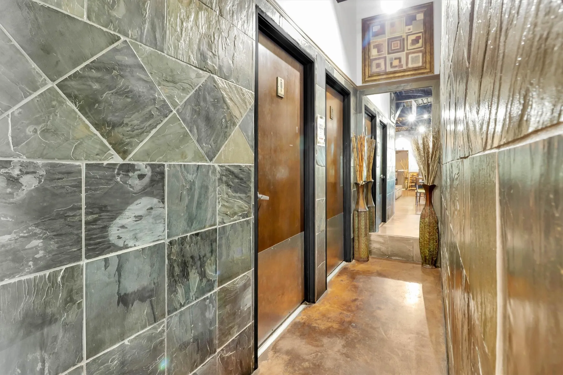 Hallway featuring textured wall panels and a slate tile accent wall