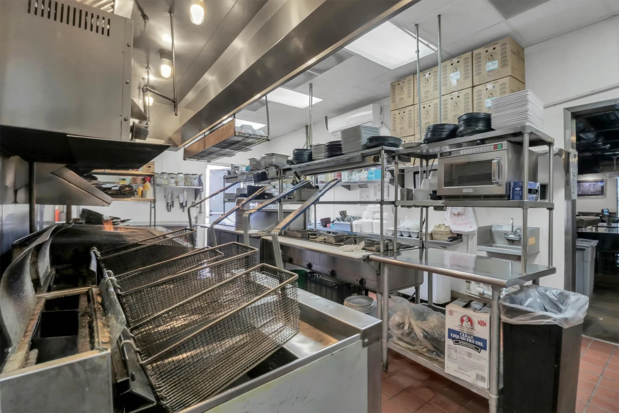 Commercial kitchen featuring stainless steel appliances and extensive work surfaces