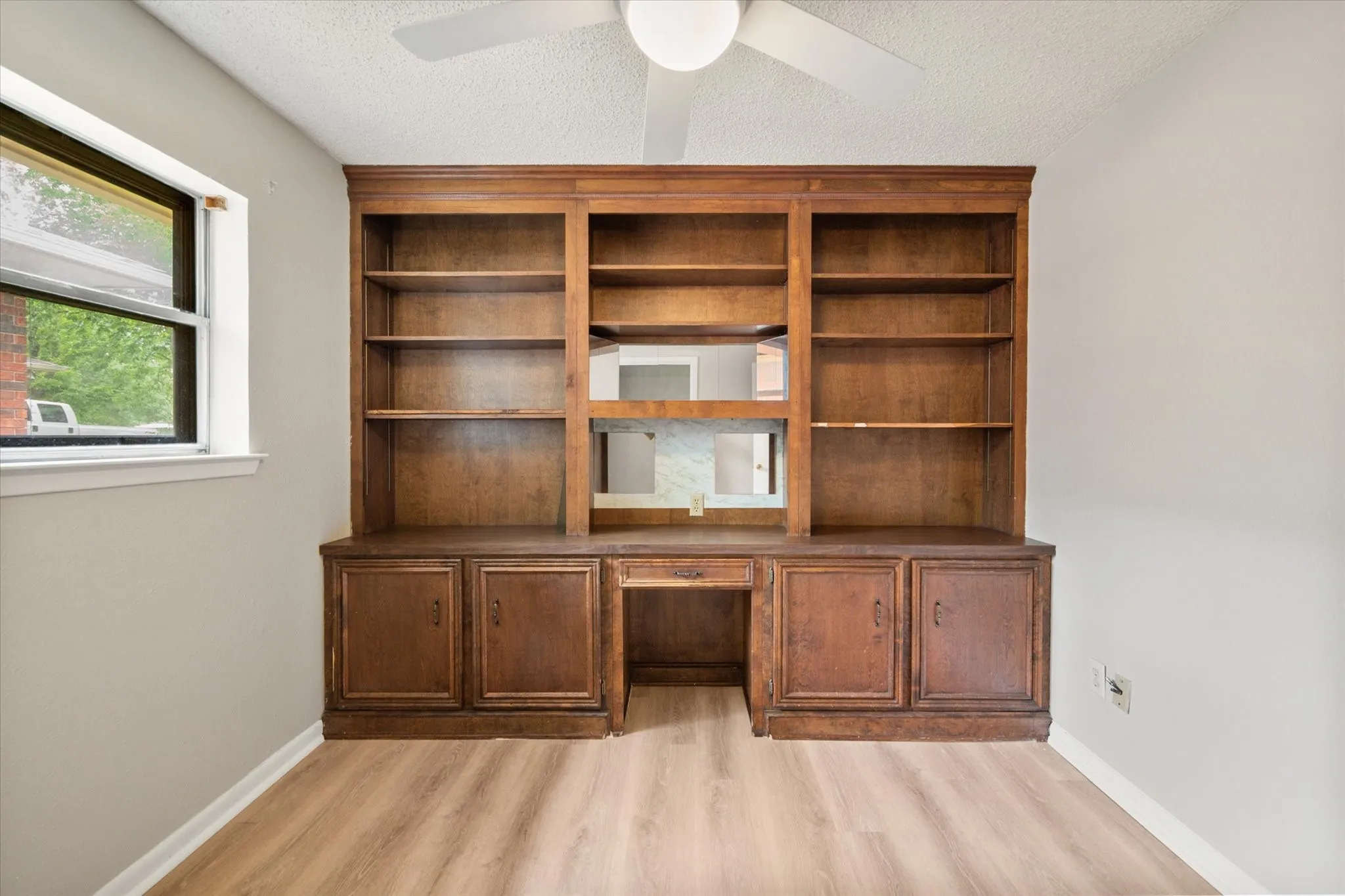 Built-in wood cabinetry with shelving, a desk area, and lower storage cabinets