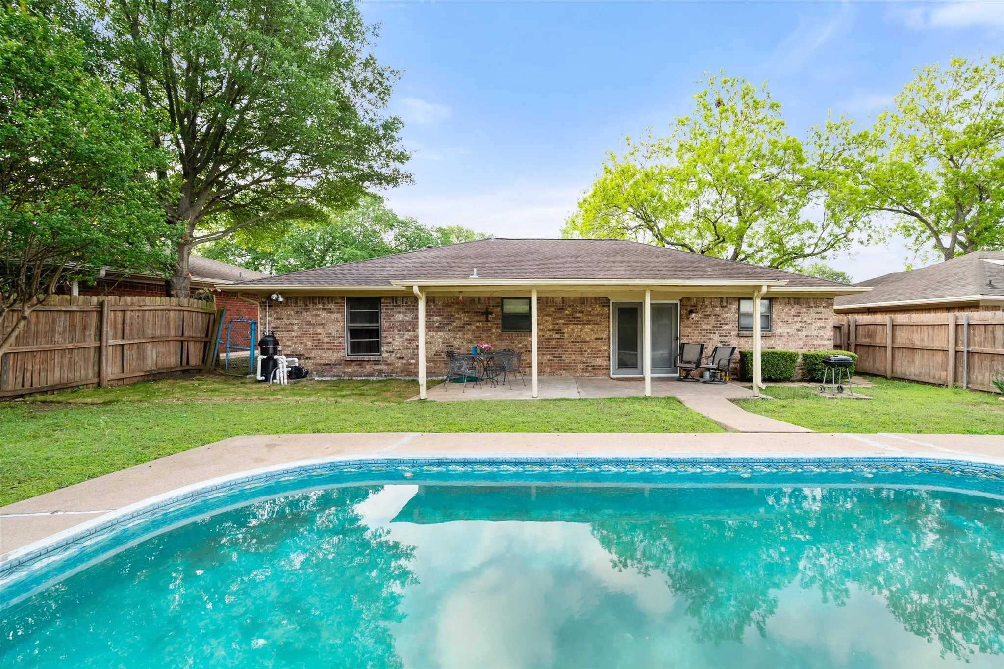 In-ground swimming pool with concrete surround