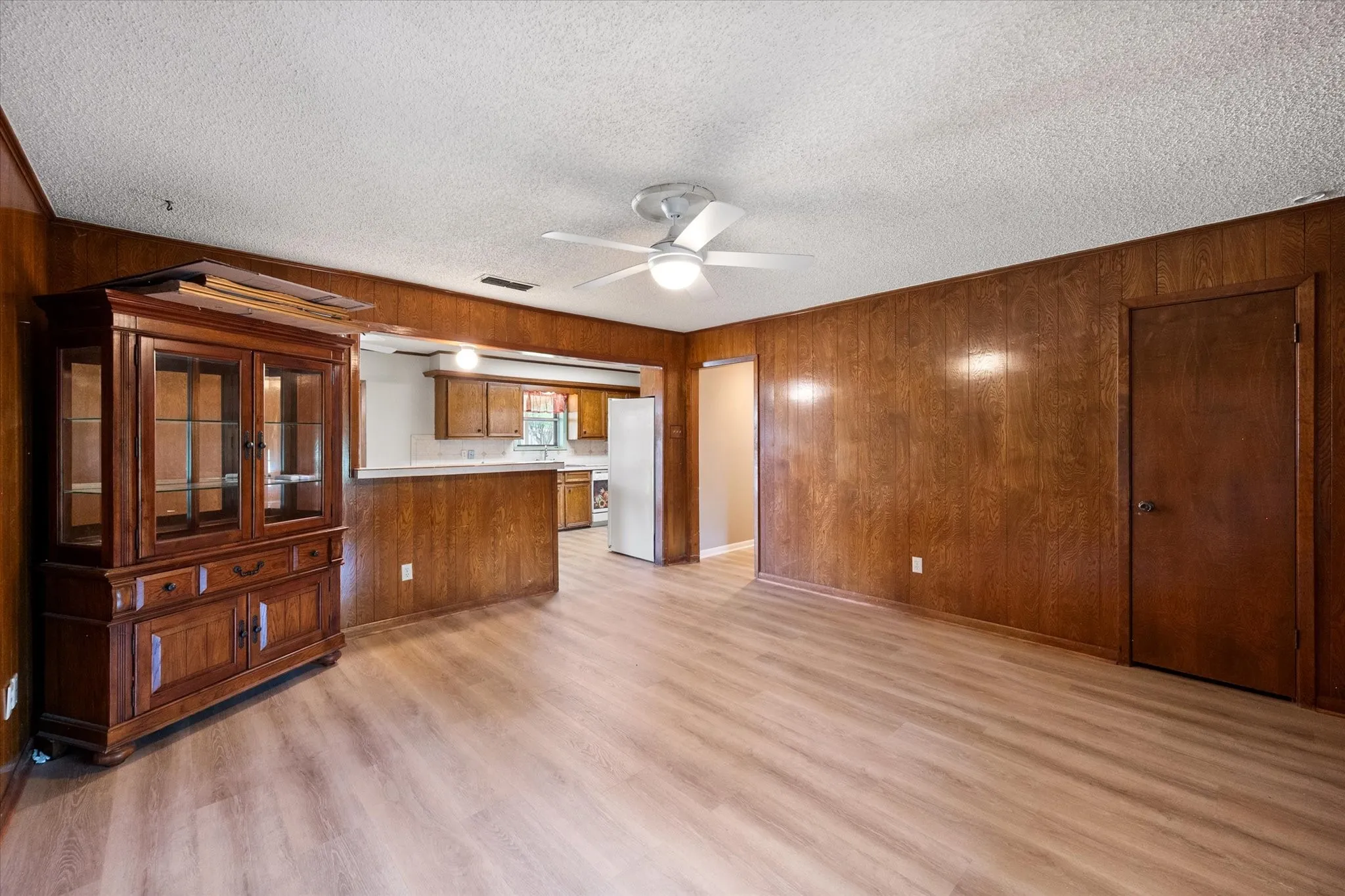 Open concept living area with wood-finish wall paneling