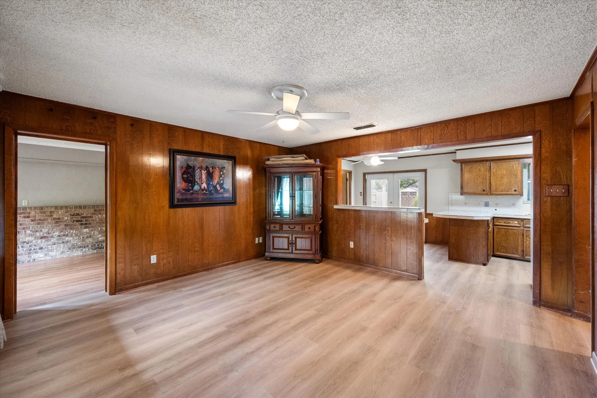 Wood-finish flooring throughout, complemented by wood paneling on walls