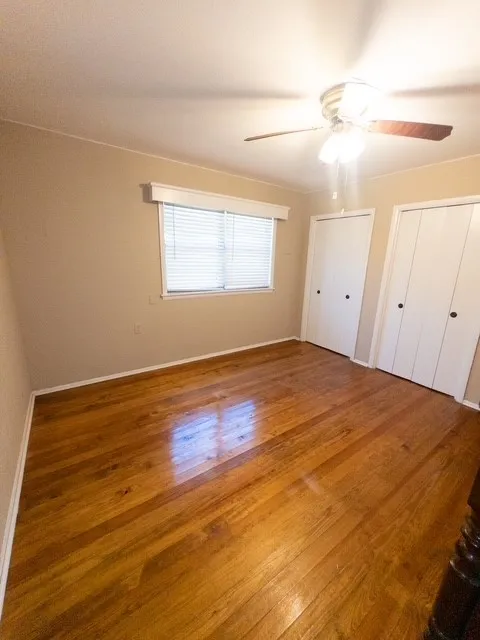 Bedroom featuring wood-finish flooring, neutral wall color, and a ceiling fan with integrated lighting