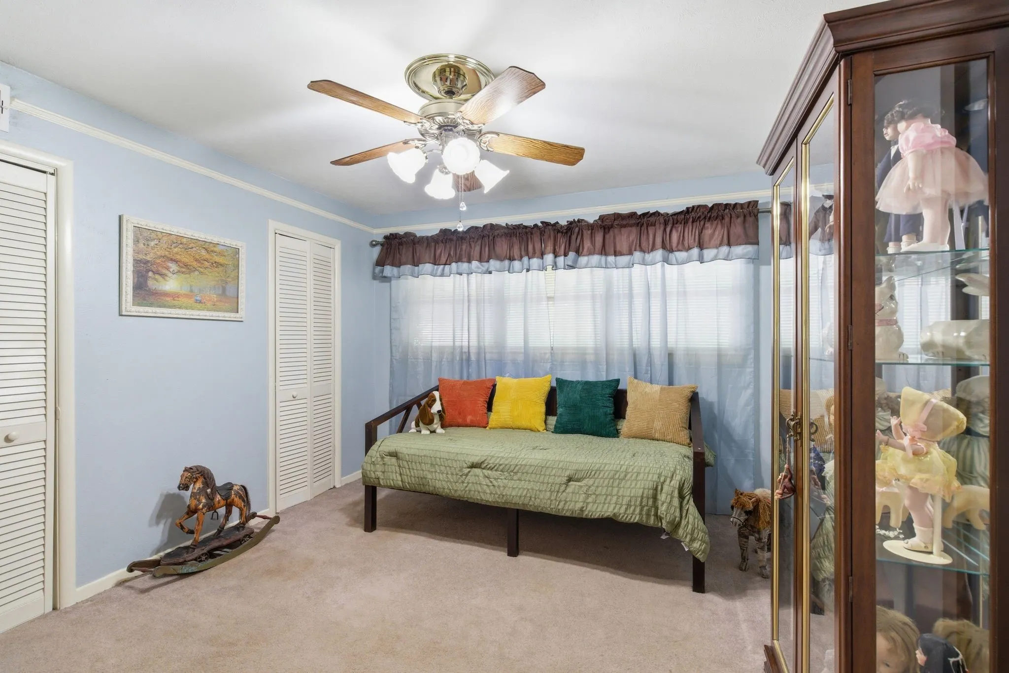 Room featuring light blue walls and beige carpet