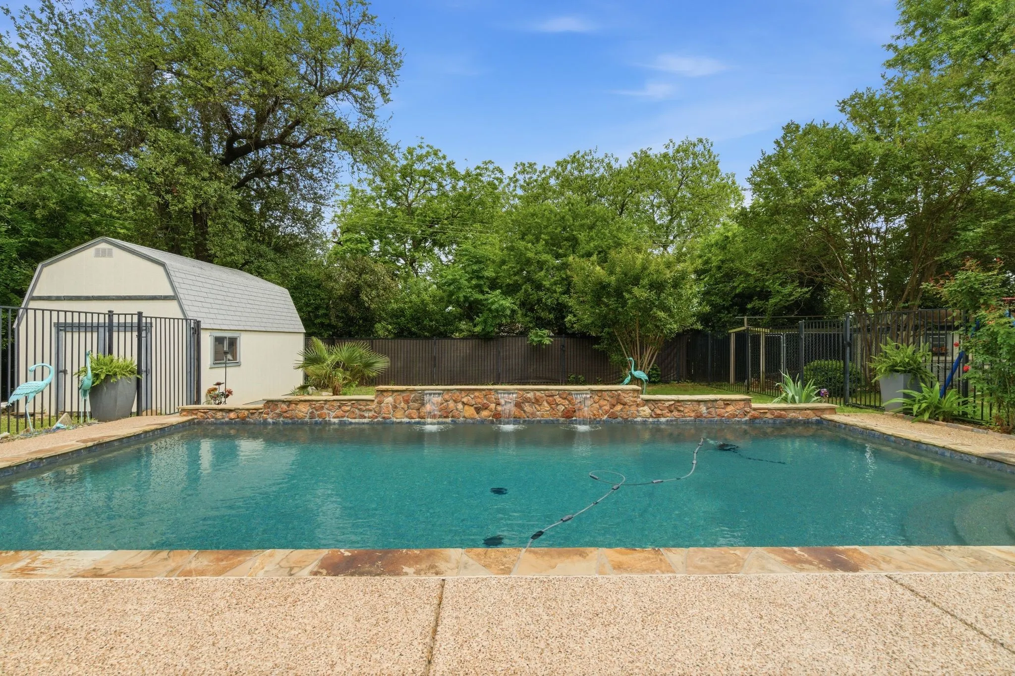 Swimming pool with a stone coping and textured concrete decking