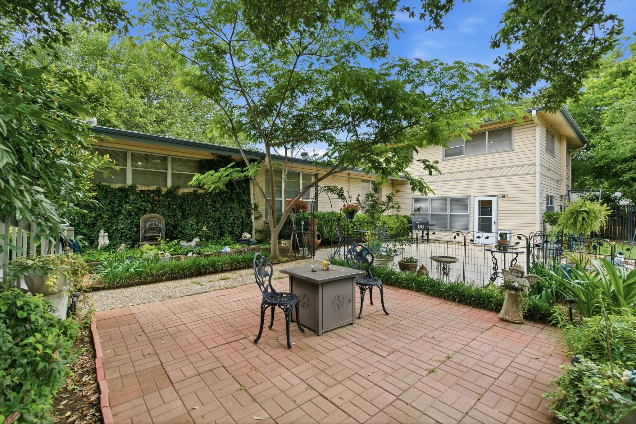 Brick paver patio surrounded by lush greenery