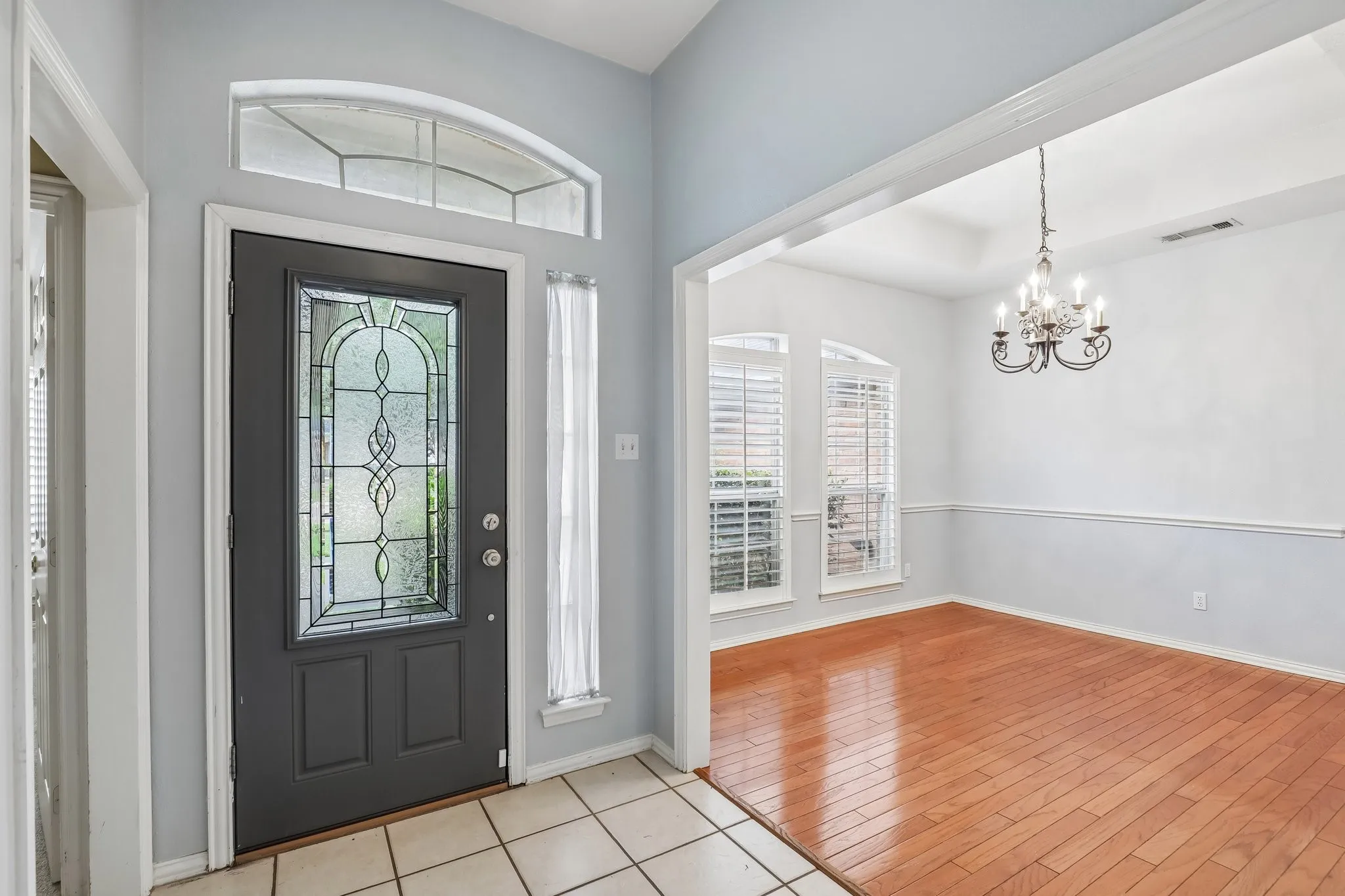 Entryway featuring a decorative leaded glass door with an arched transom window