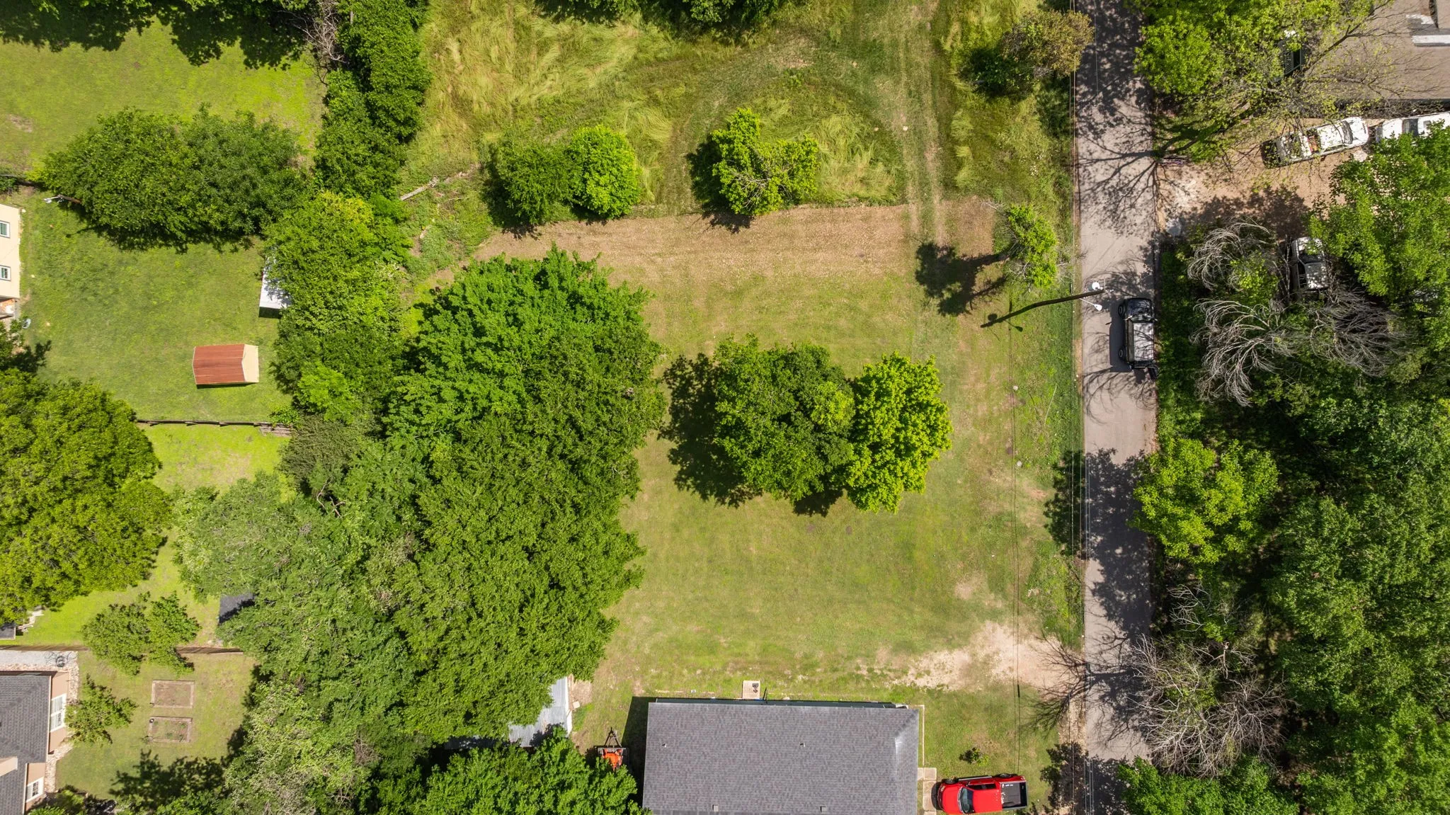 Expansive land parcel featuring existing mature trees and grassy areas