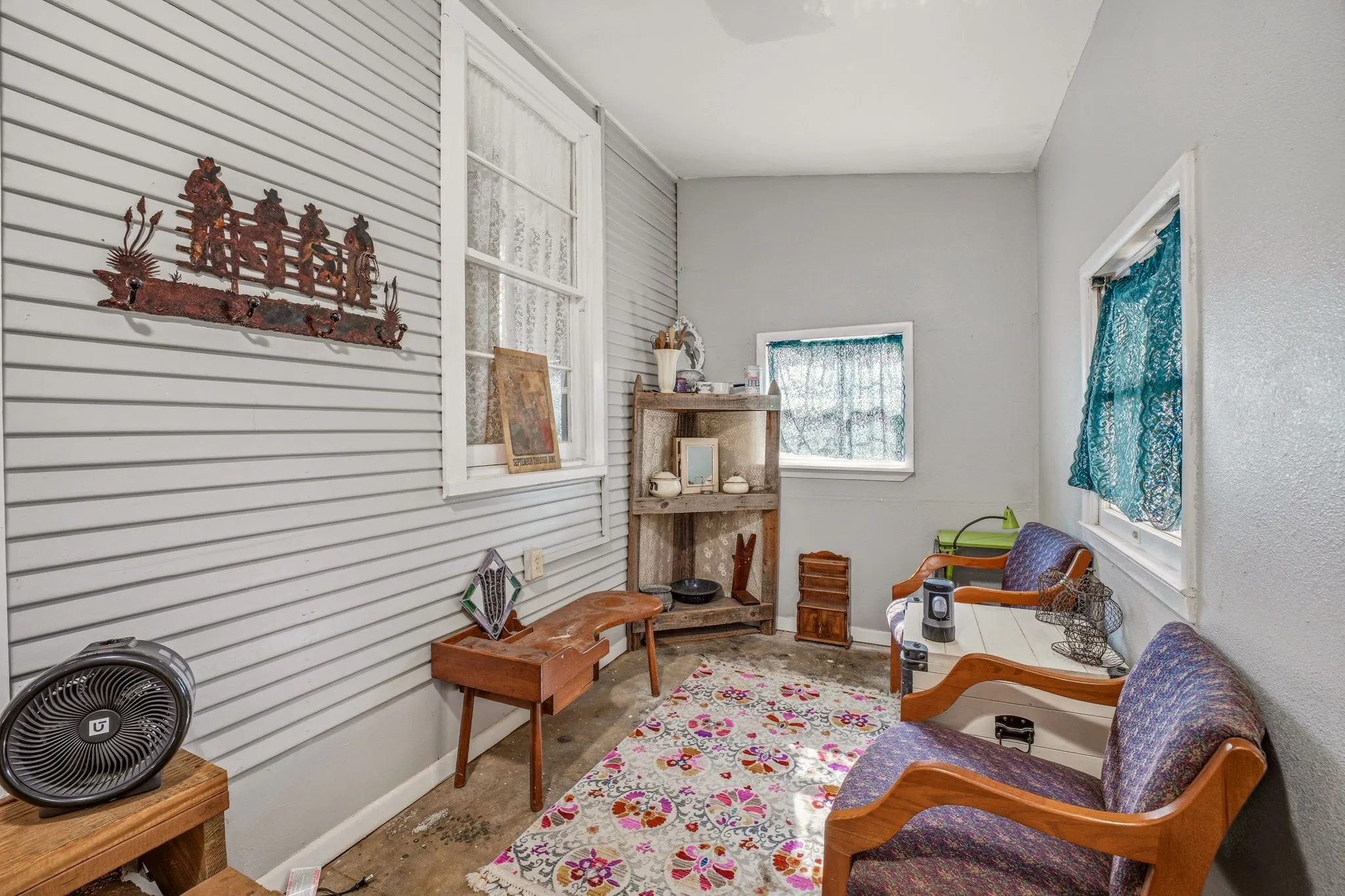 Enclosed porch featuring horizontal paneling and multiple windows