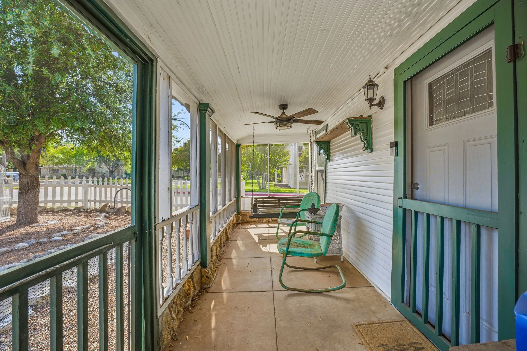 Screened-in porch featuring a concrete floor and white beadboard ceiling