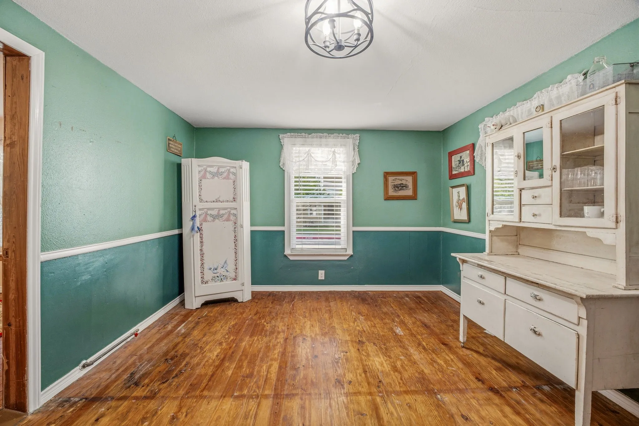 Room featuring wood-finish flooring, two-tone wall treatment, and a central ceiling light fixture