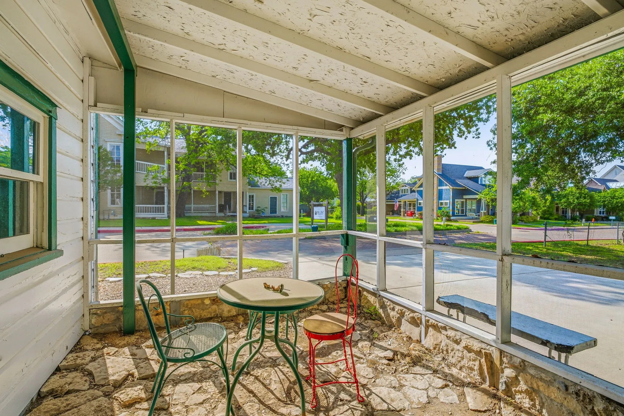 Screened-in porch featuring a stone floor and exposed wood ceiling