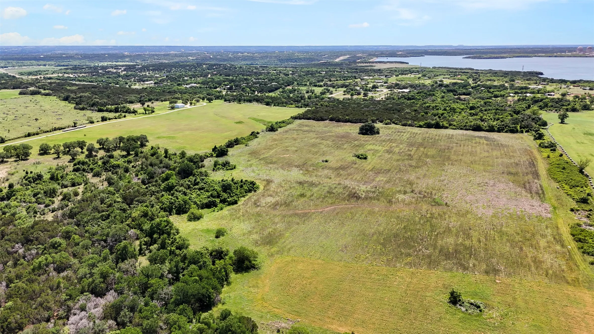 Expansive acreage featuring a mix of open fields and mature tree lines