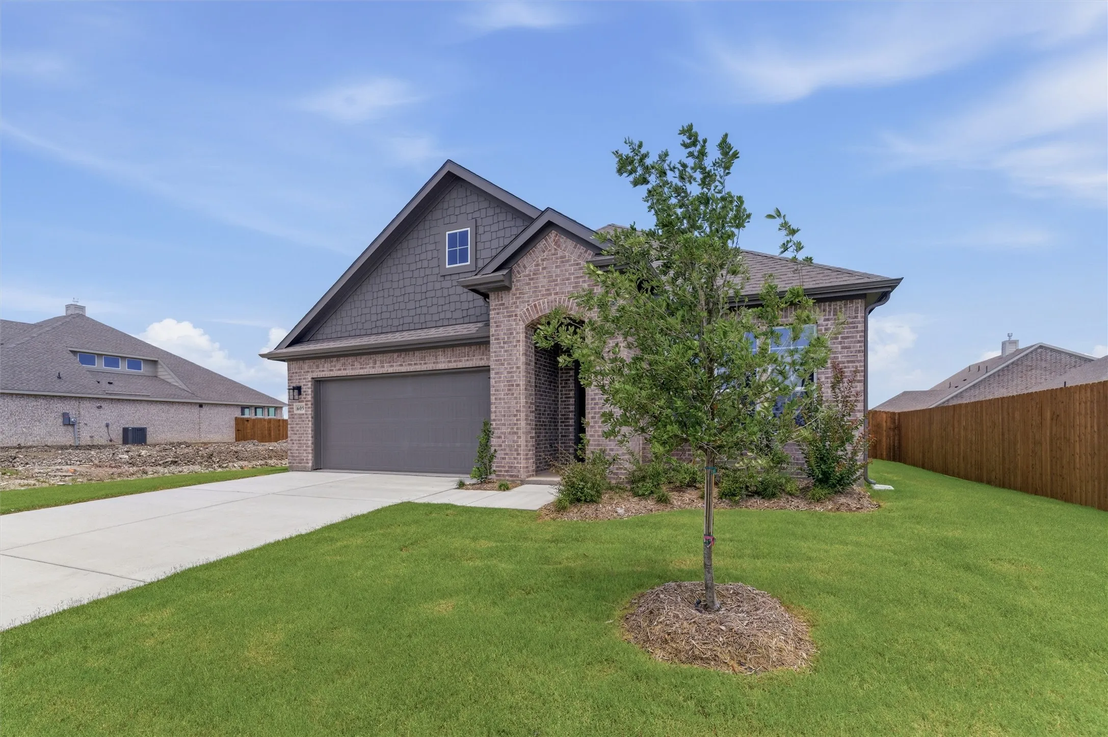 Brick and shingle-sided exterior with a prominent two-car garage