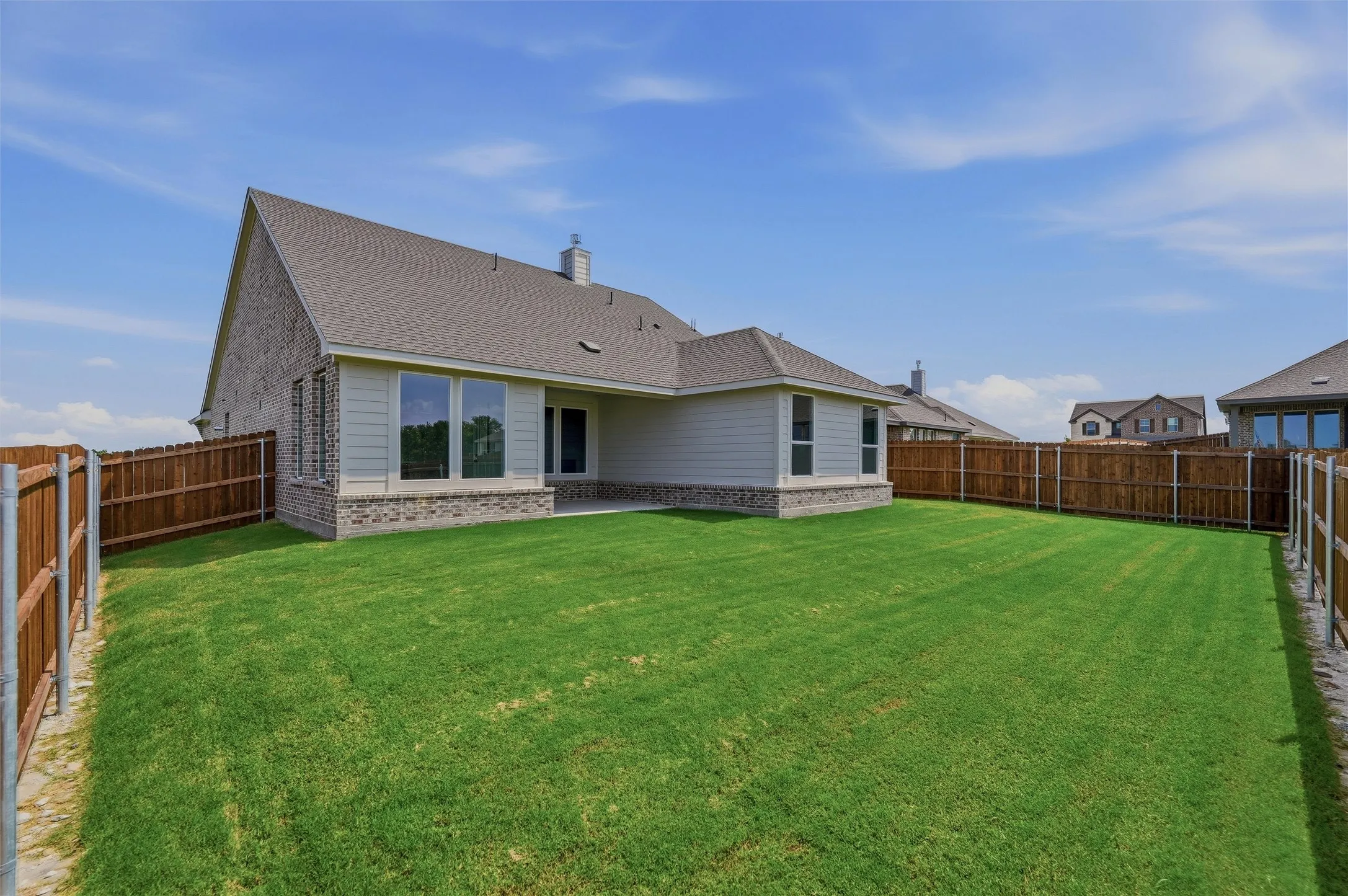 Expansive lawn bordered by wood fencing