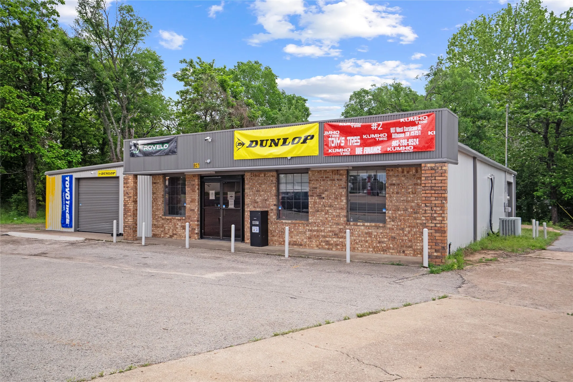Commercial building featuring a brick facade and a gray roll-up garage door